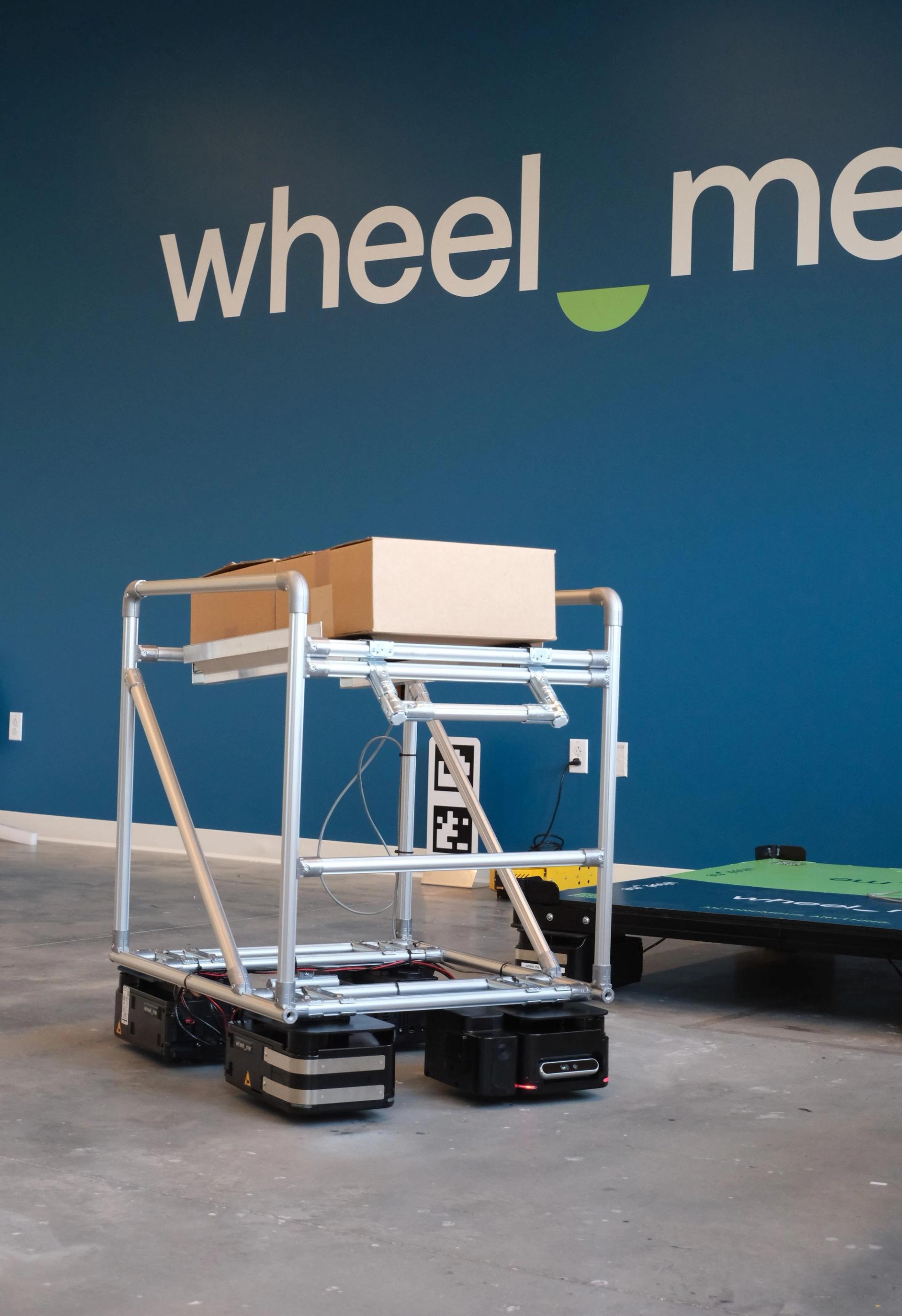 A wheel.me cart carrying a package for delivery.