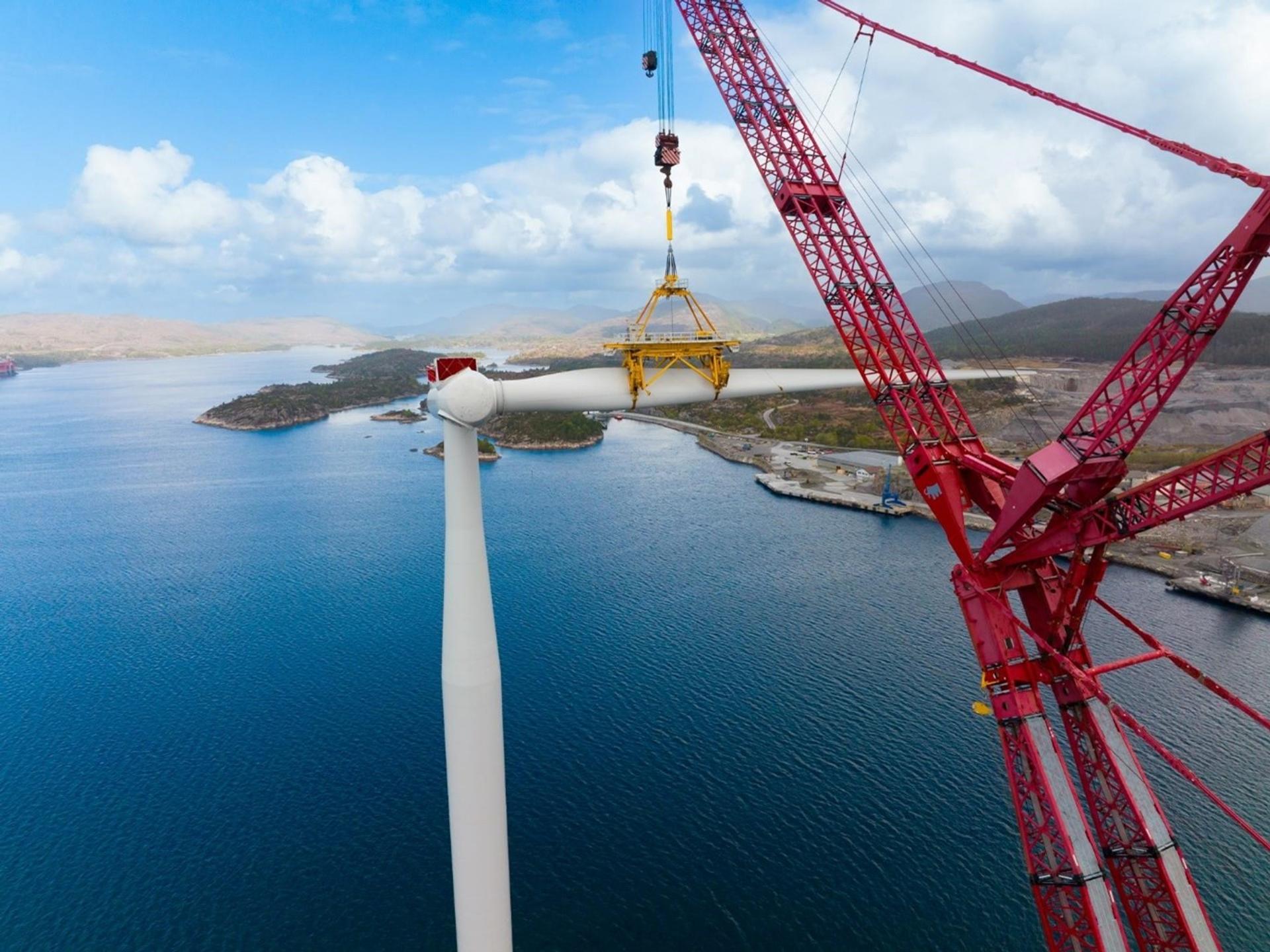 Offshore wind turbine being installed by a red crane
