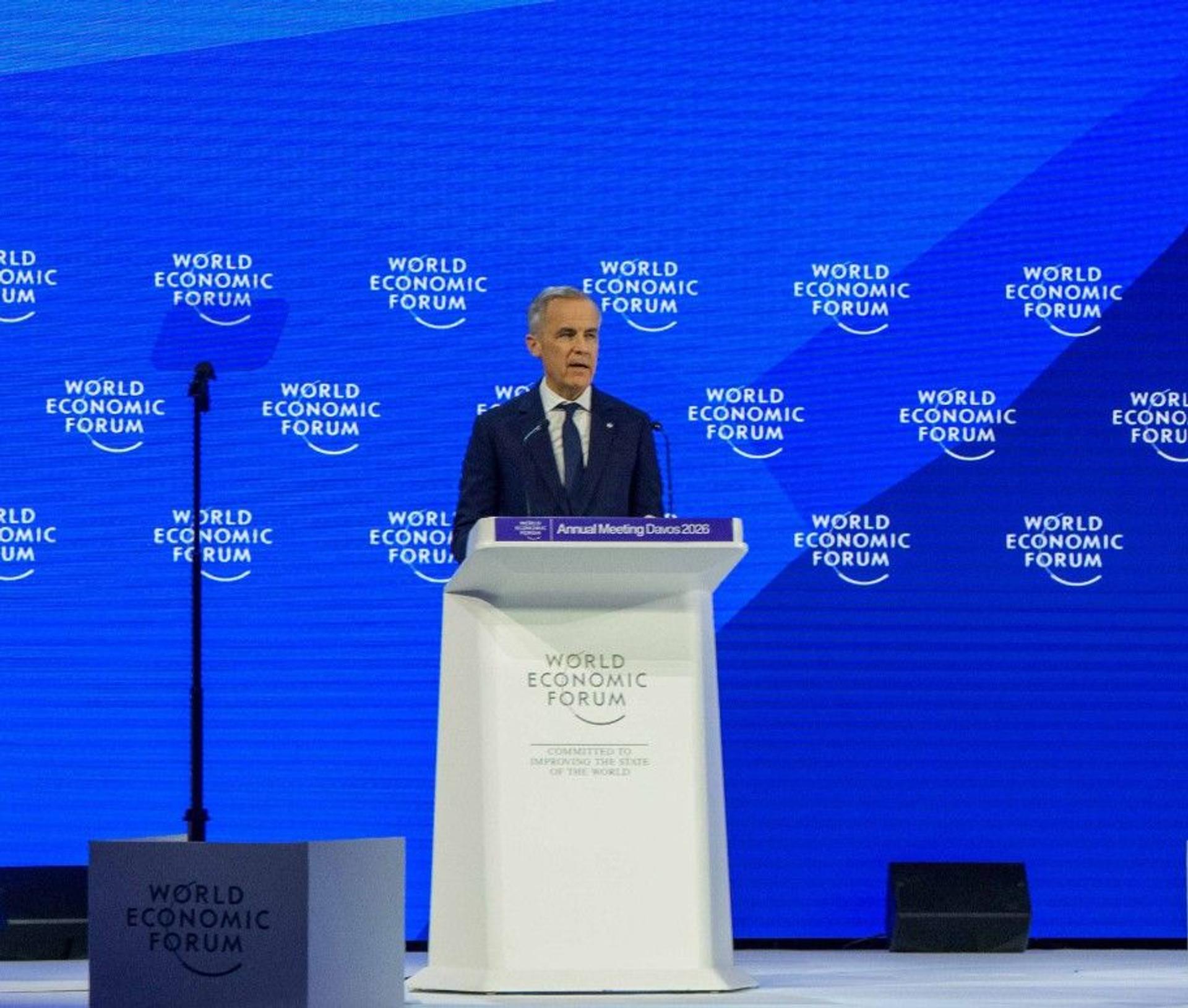 Prime Minister of Canada Mark Carney at a white podium in front of a blue background at World Economic Forum in Davos