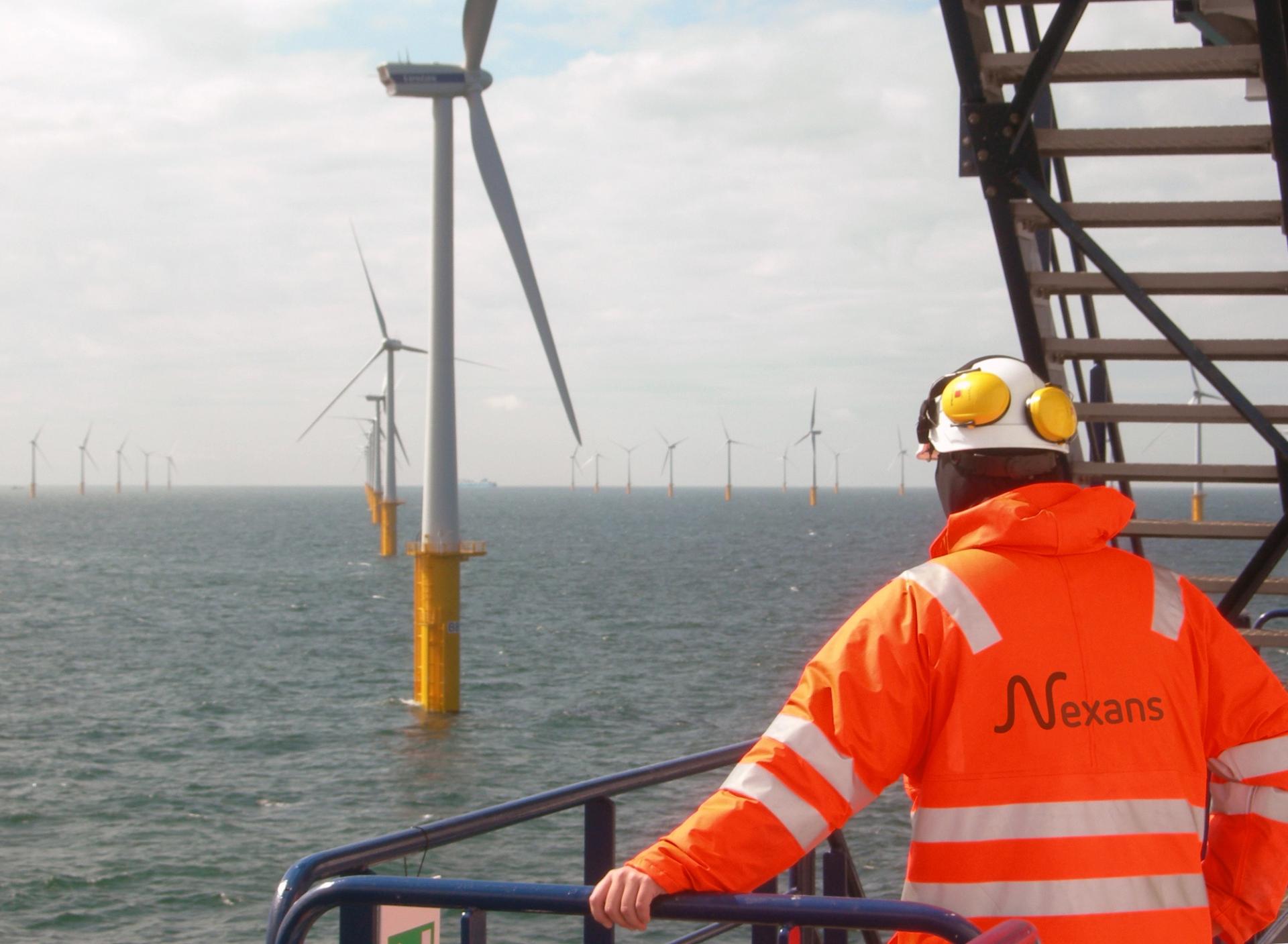 Nexans worker on boat looking at a floating wind farm