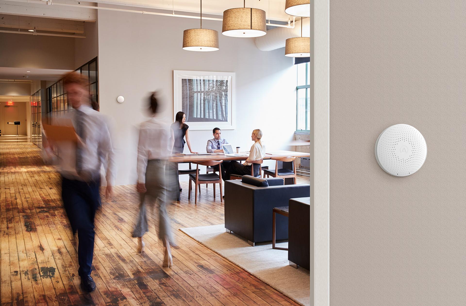 people in an office with a air sensor on the wall