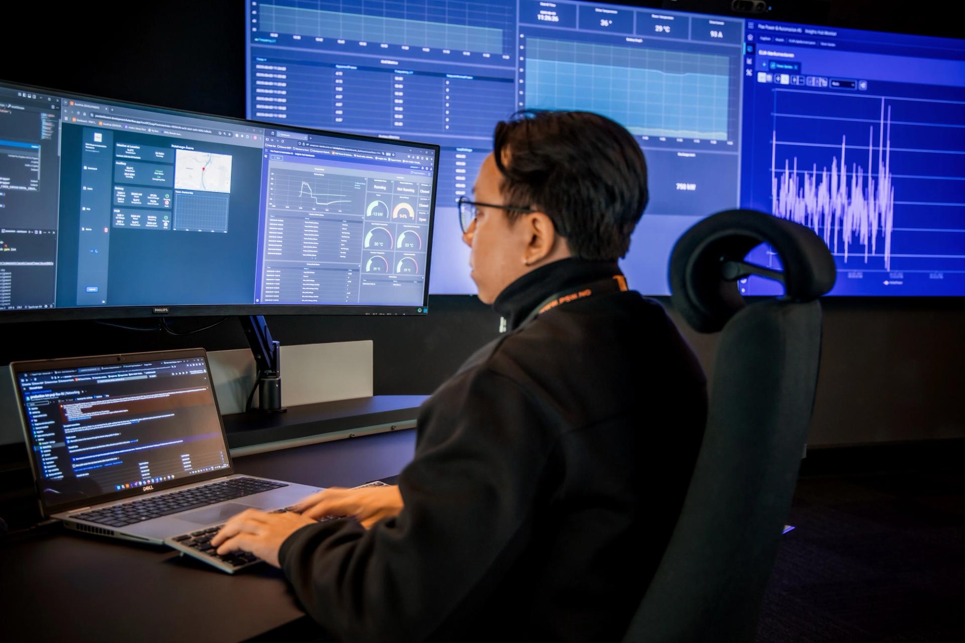 Woman in front of 6 computer screens