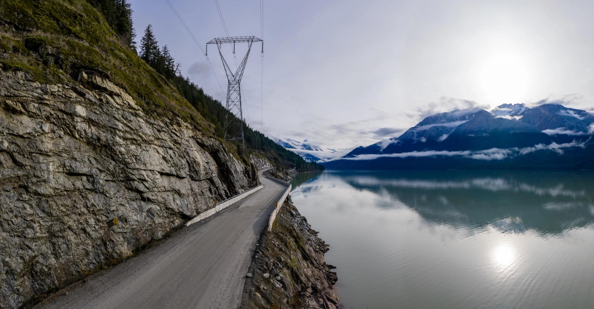 Power line on a road on the edge of a mountain overlooking a fjord