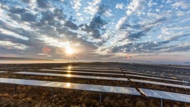 Solar panels under a blue cloudy sky