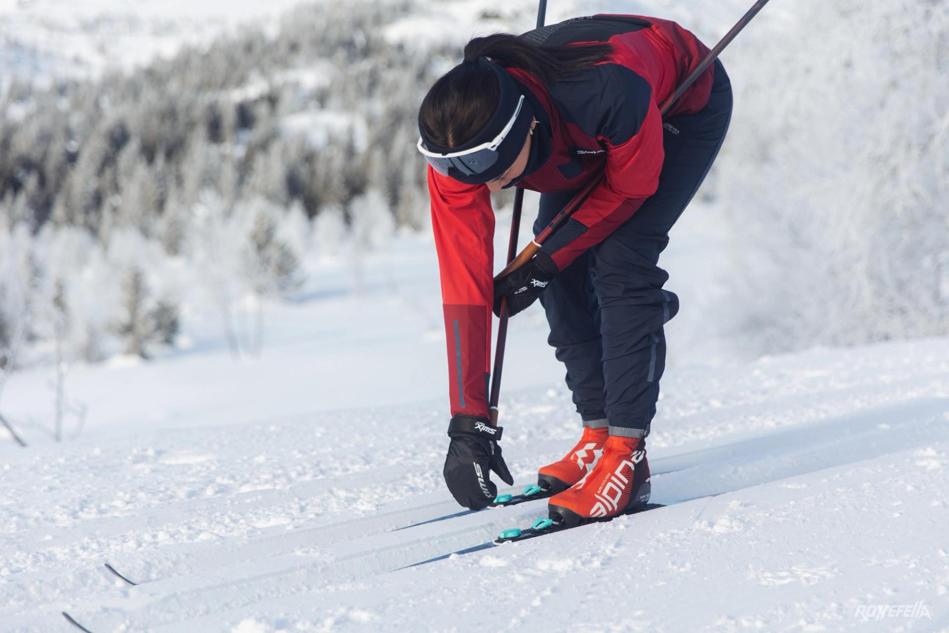 A girl skiing, adjusting her Rottefella MOVE switch bindings