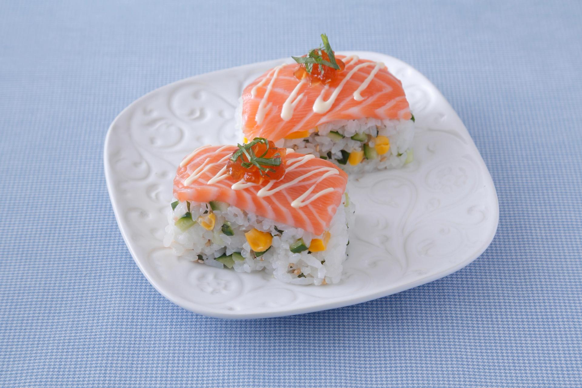 two pieces of salmon sushi on a white plate