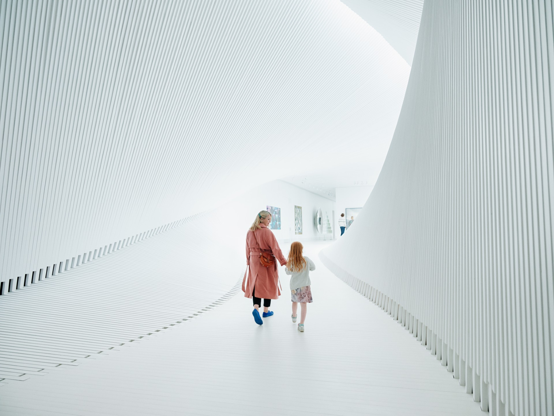 Woman and daughter walking through museum