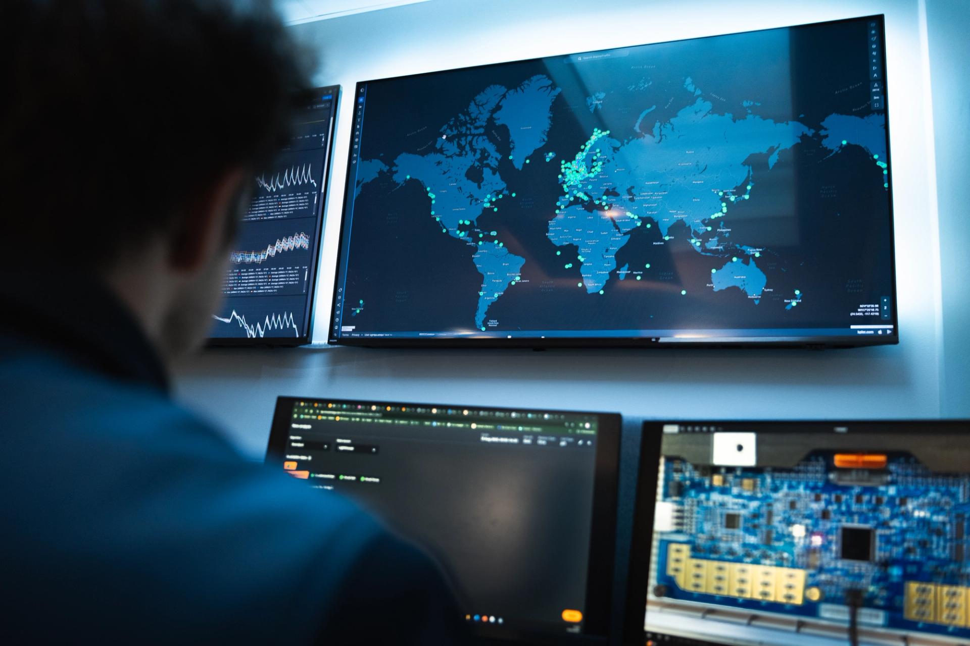 man in front of multiple screens