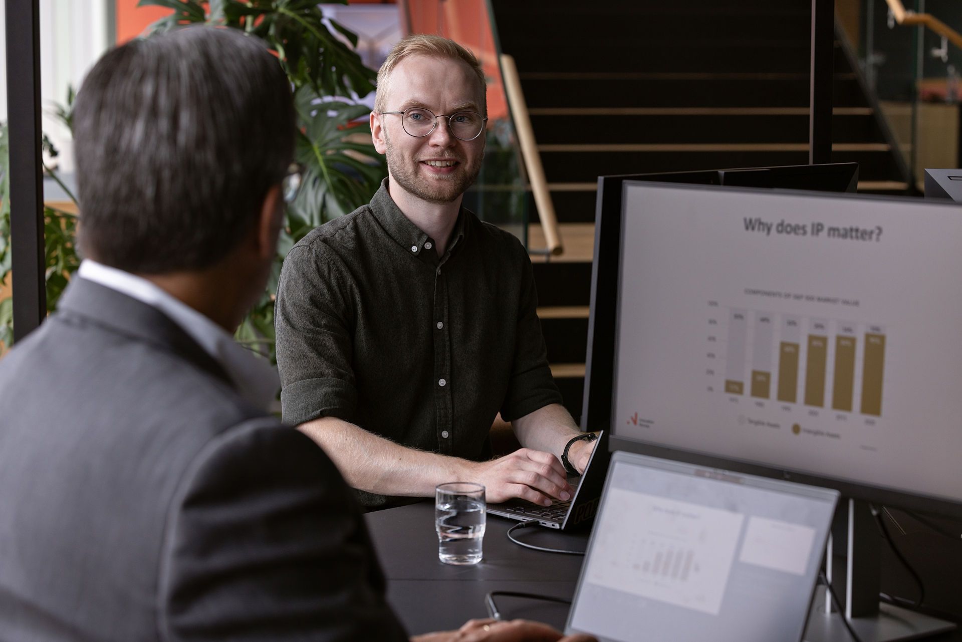 En mann foran en pc-skjerm gir rådgivning til en annen mann om IP