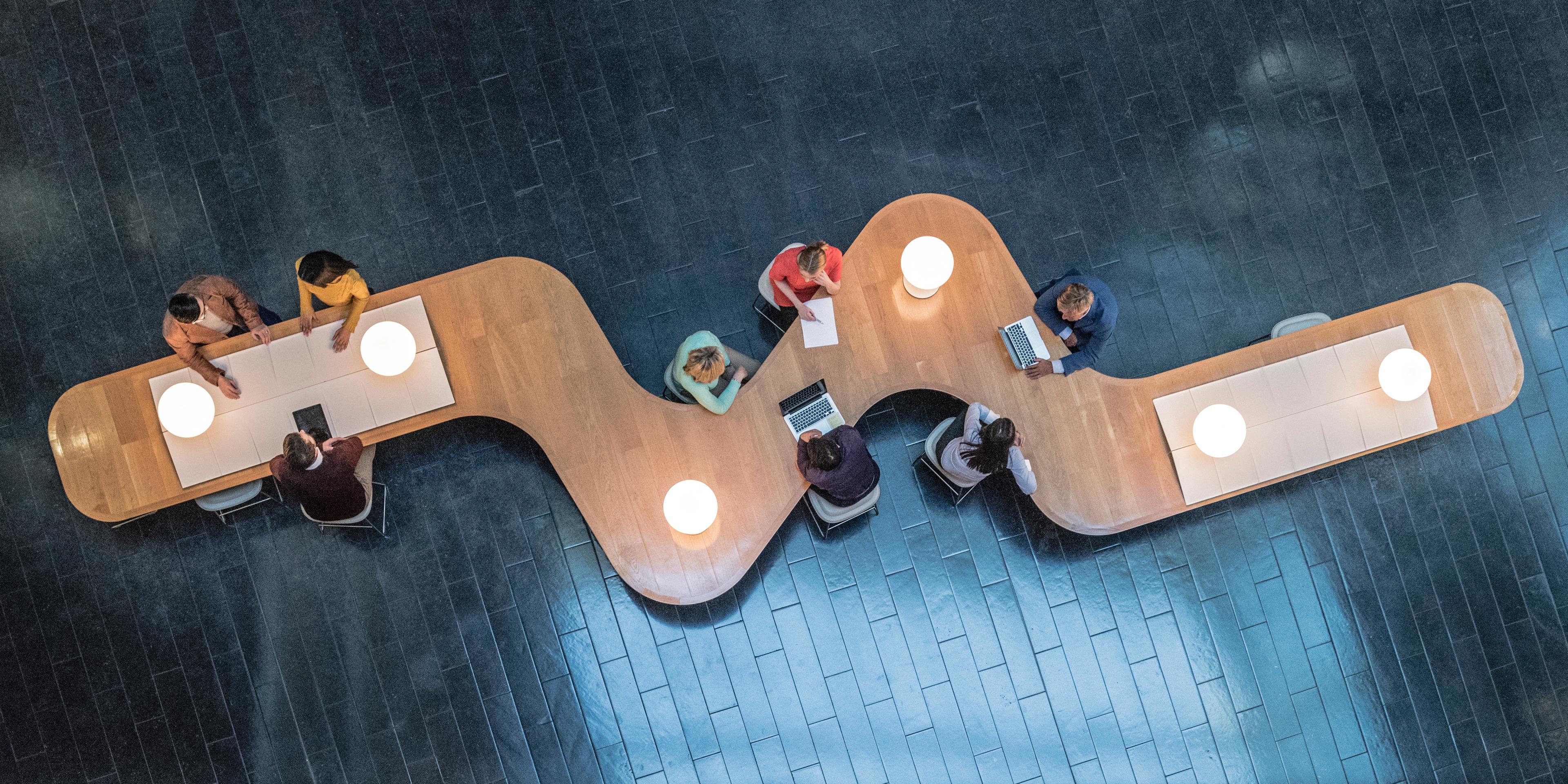 Mennesker jobber alene eller sammen ved samme bord