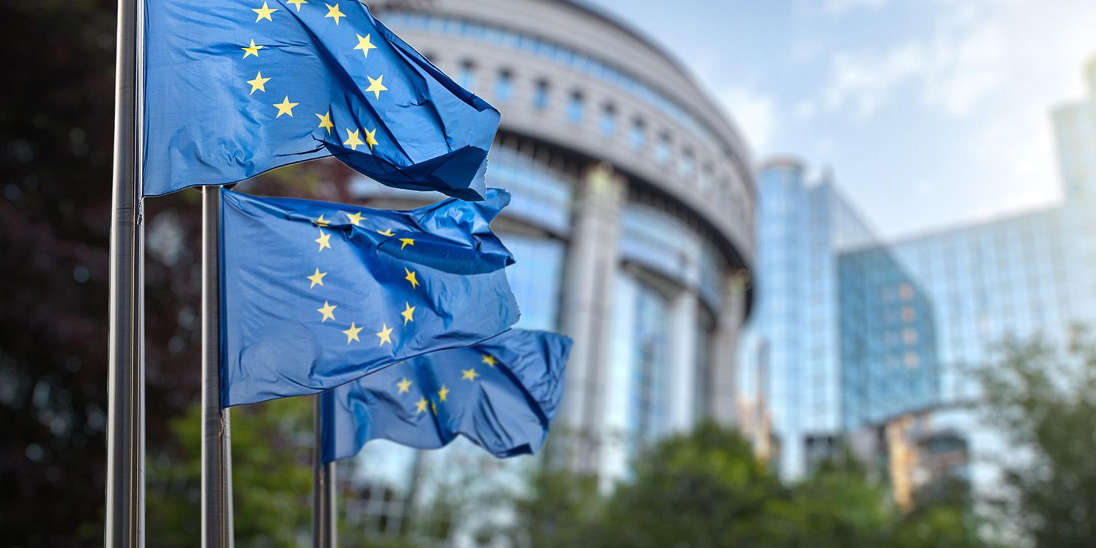 EU-flagg vaier i vinden foran bygning