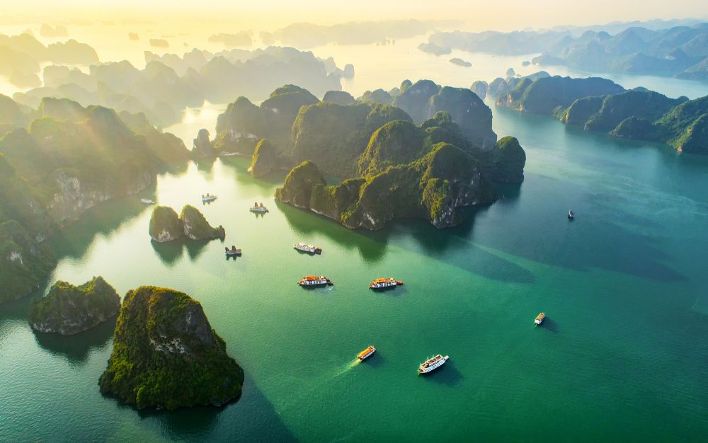 A beautiful picture of a south east asian archipelago with green waters and some small boats on the water