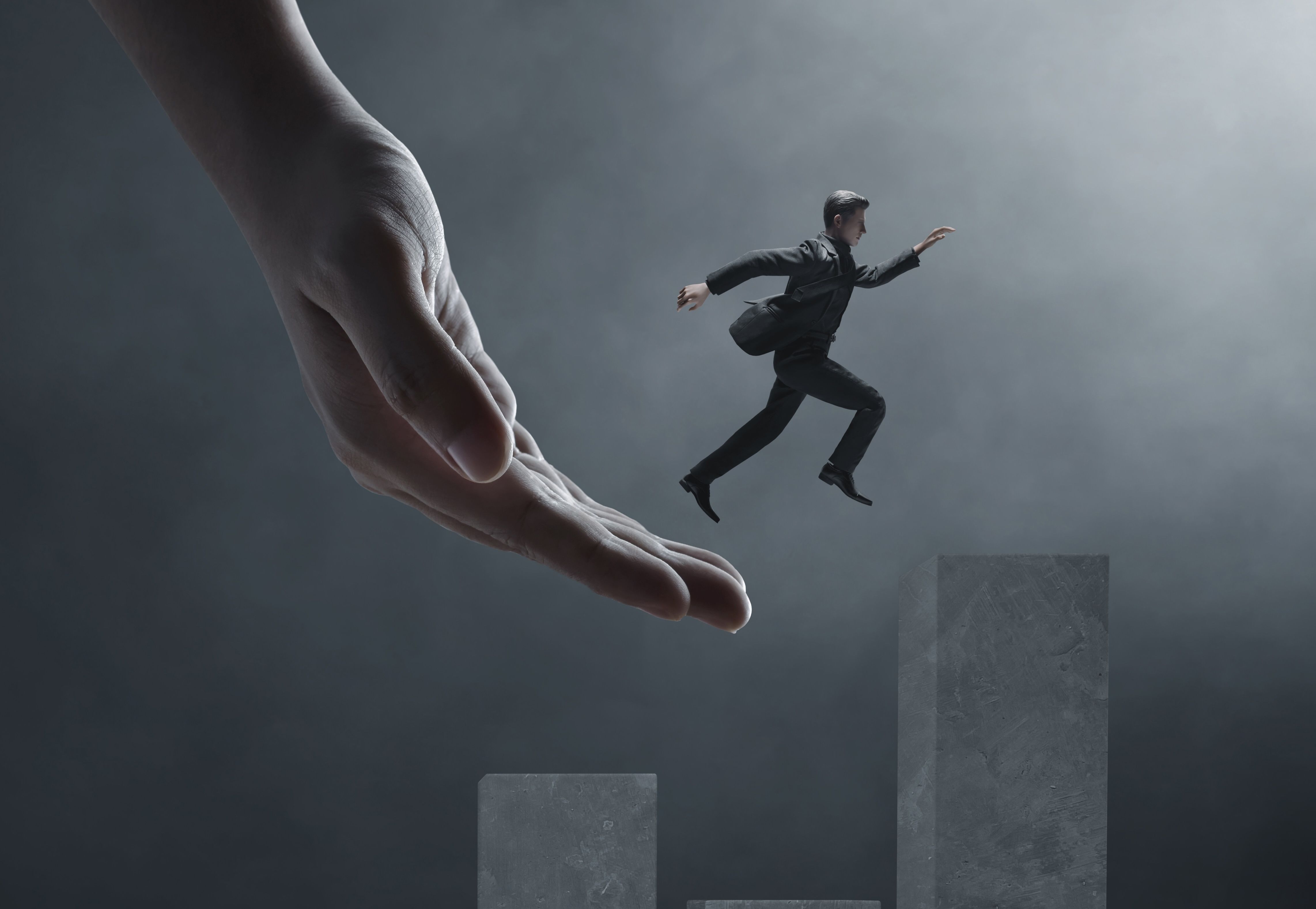 Dresskledd mann som får hjelp til å hoppe opp et trinn