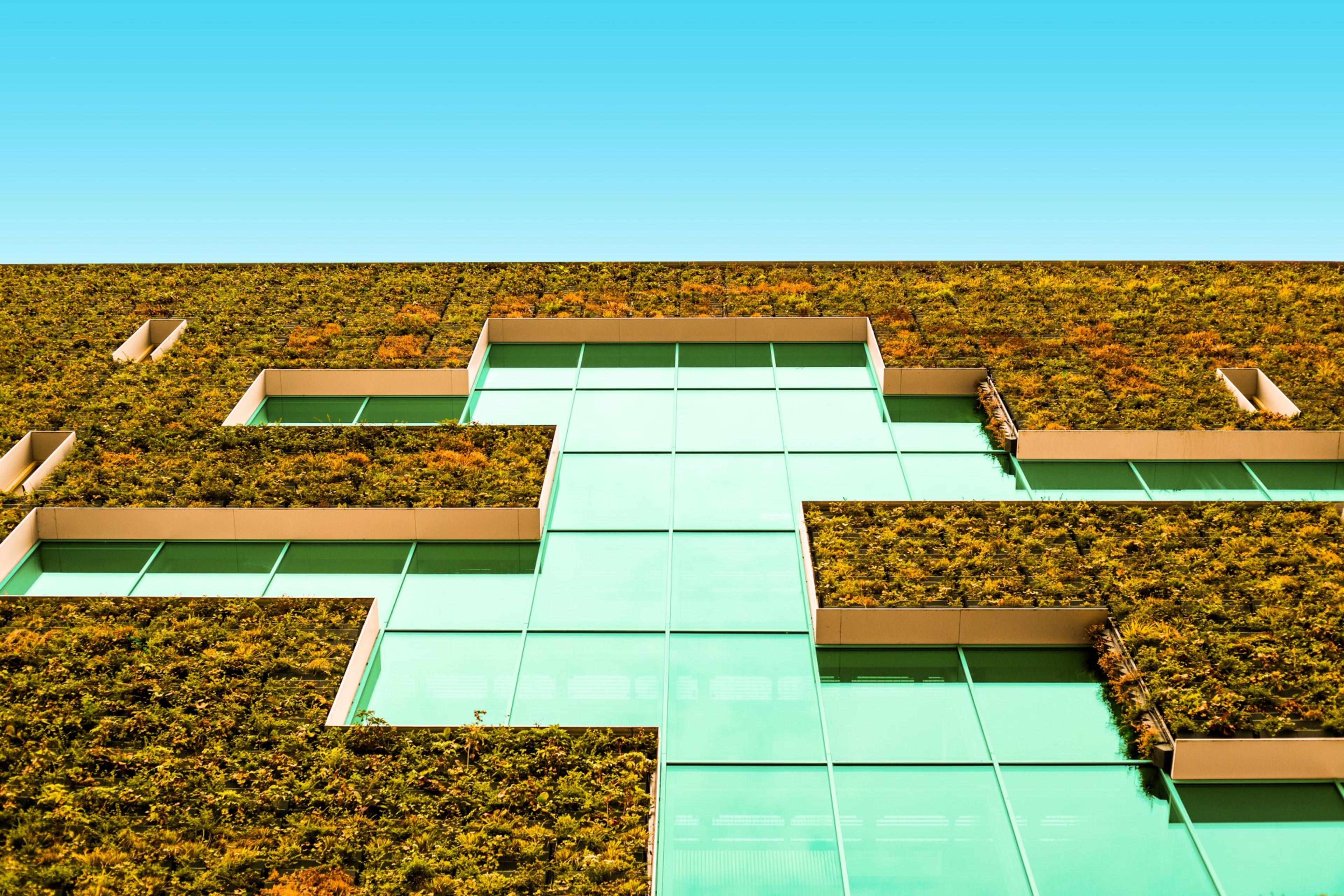 Glassbygg med grønne fasademoduler