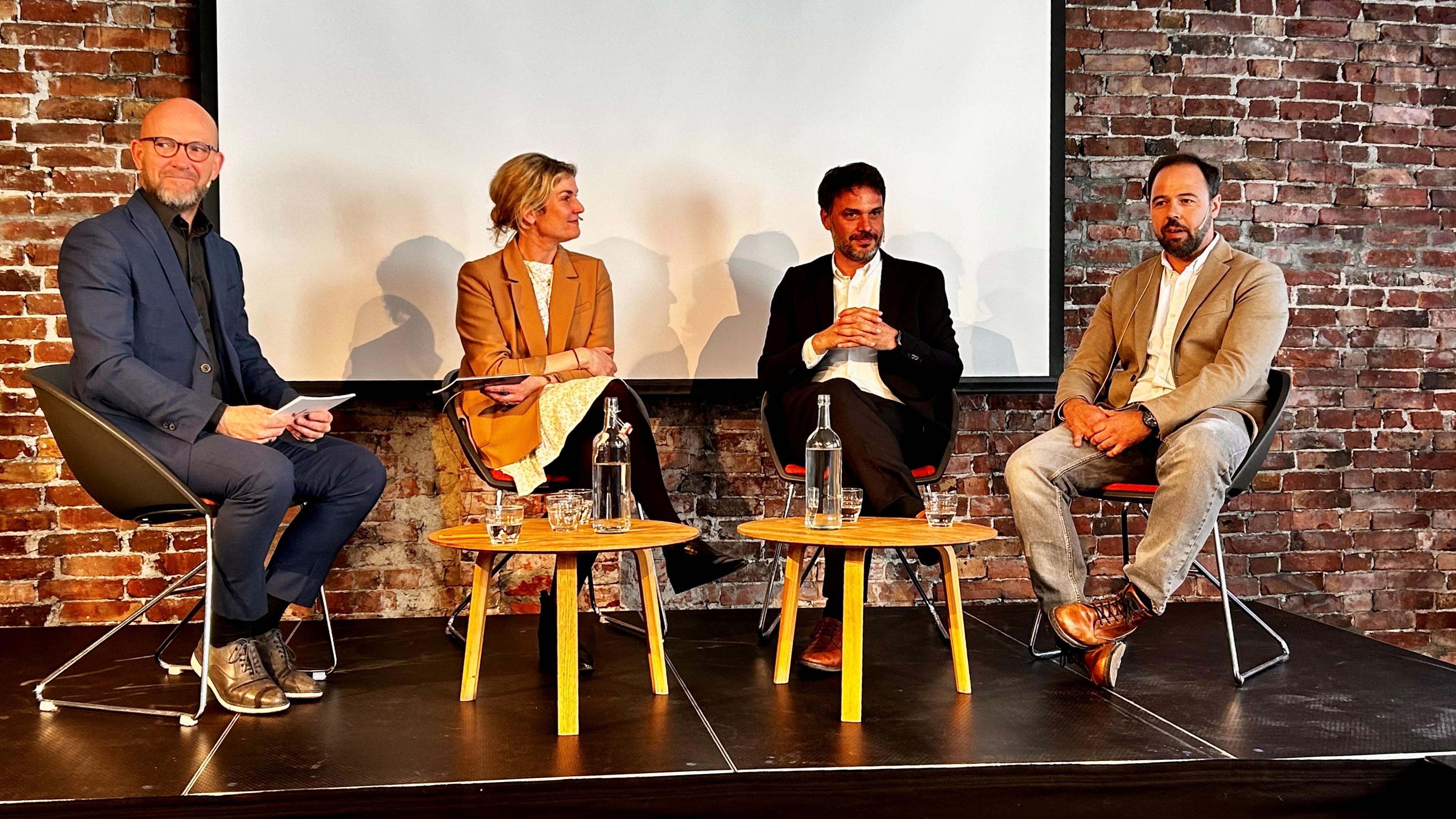 Four people discussing on a stage