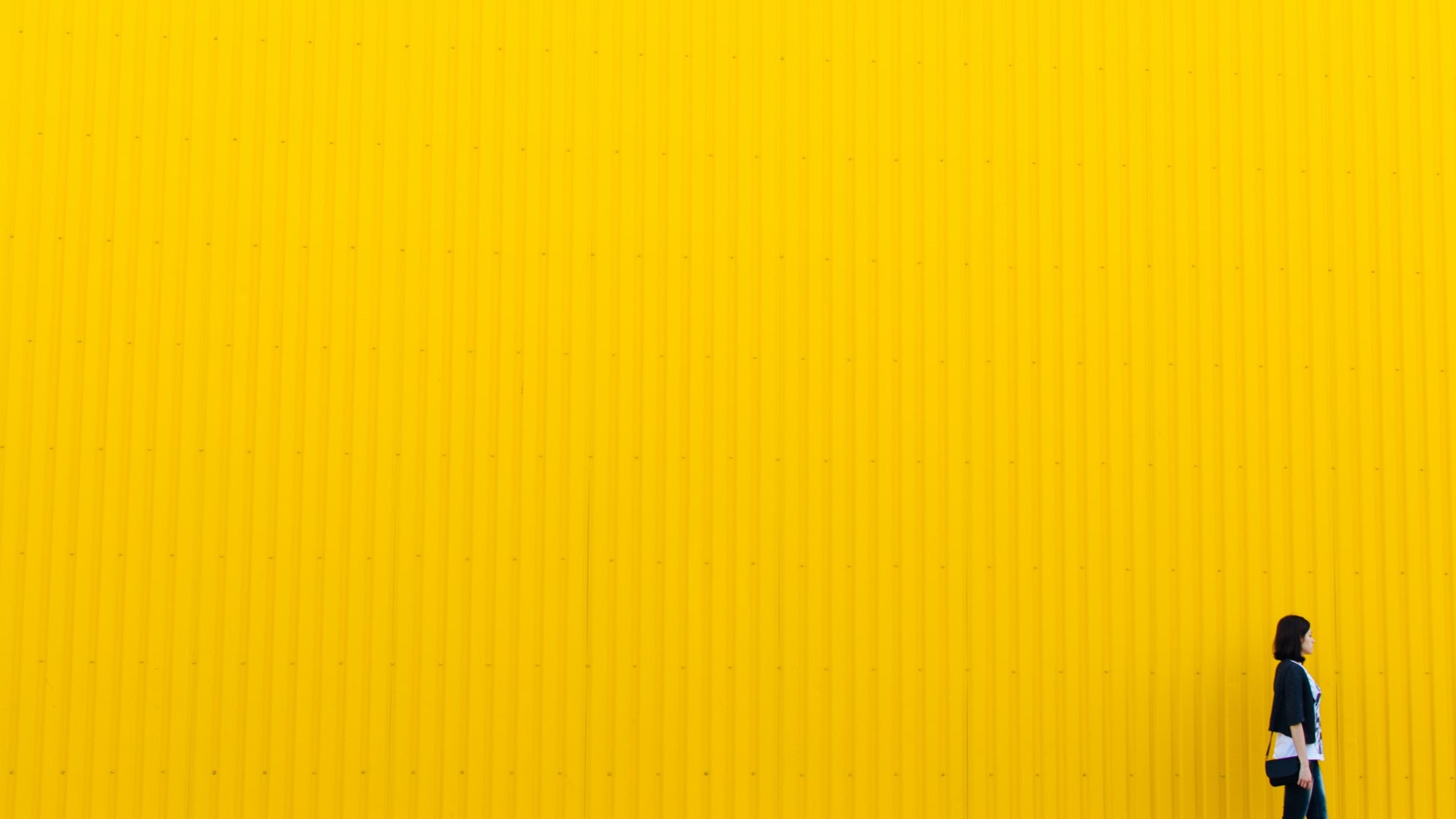 Woman in front of yellow wall