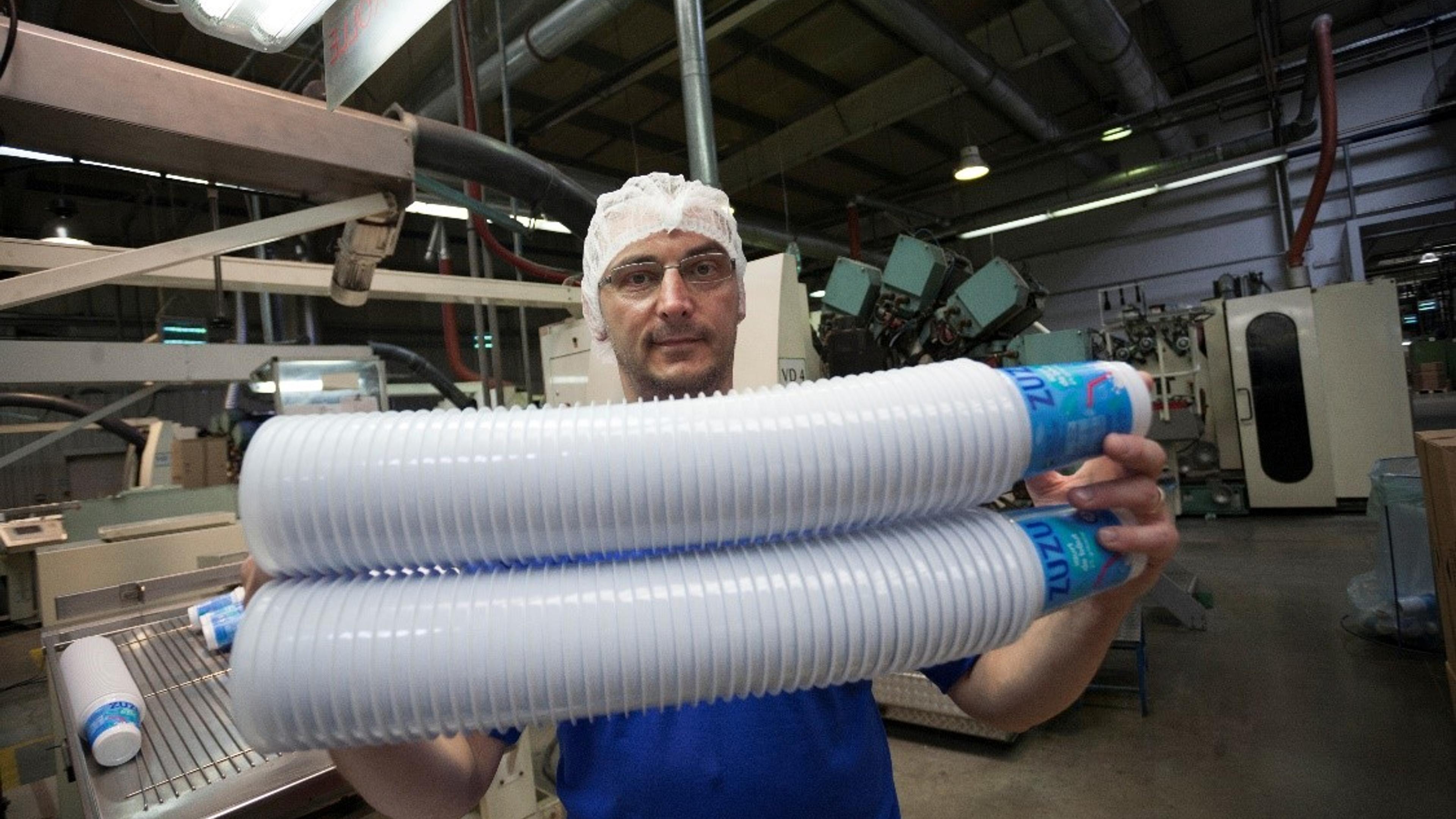 Man holding many plastic cups in a factory