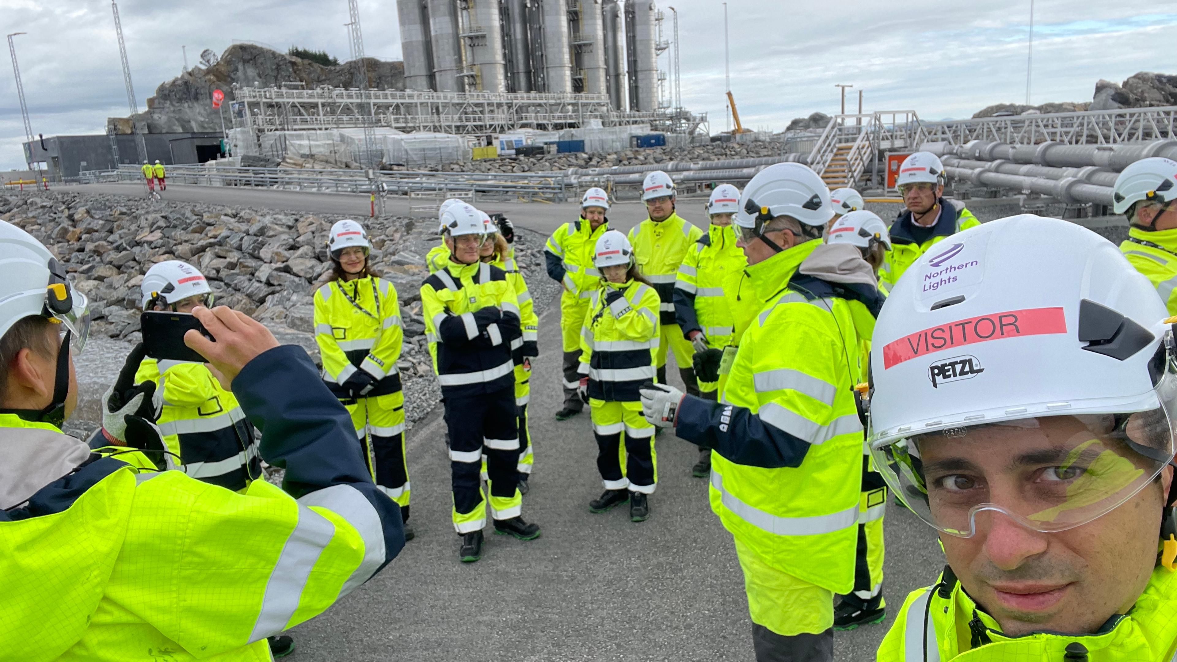 A picture of the study group at the northern lights wearing yellow suits and helmets