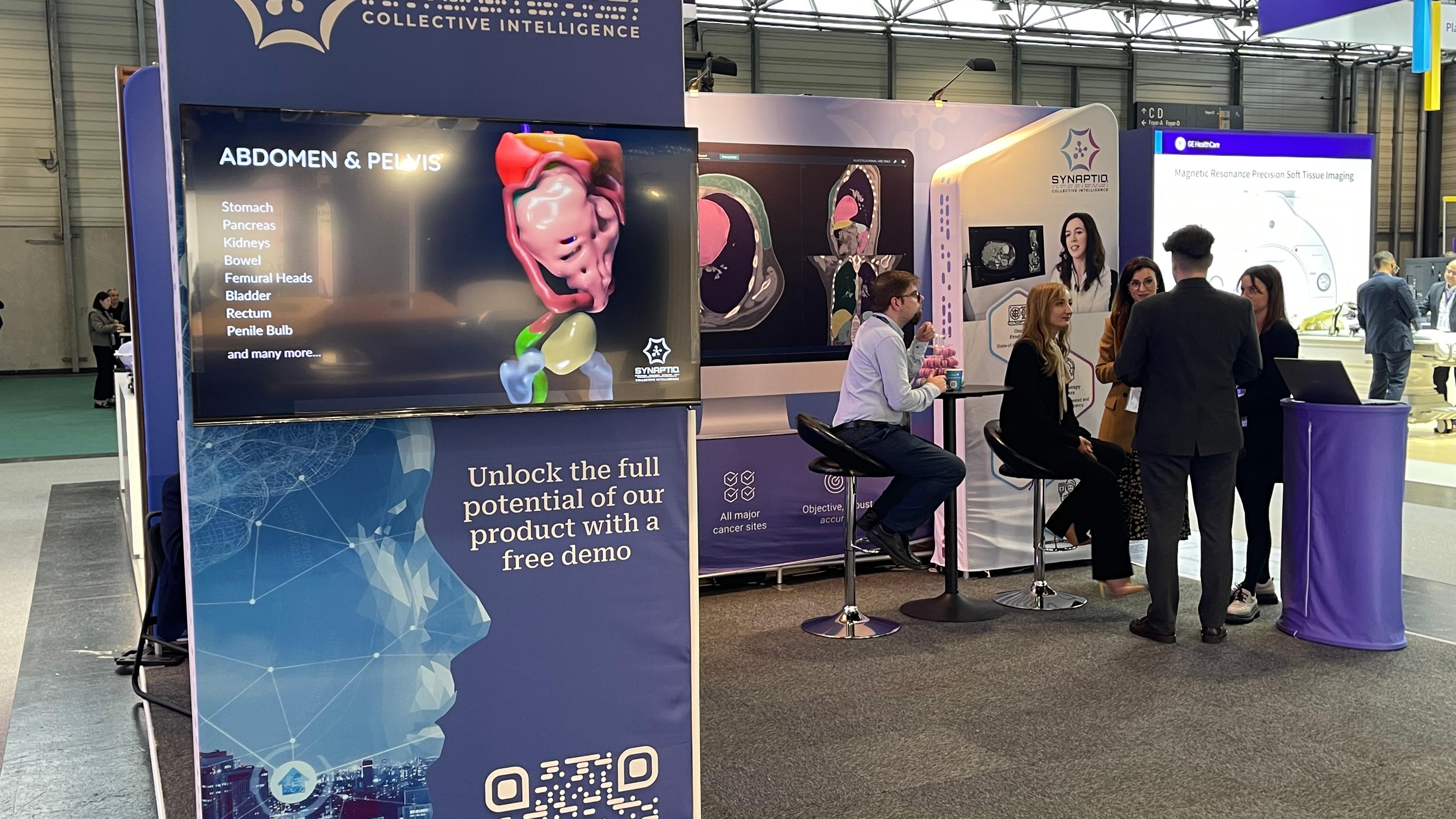 Synaptiq's stand. A stand with medical information and people standing at the stand