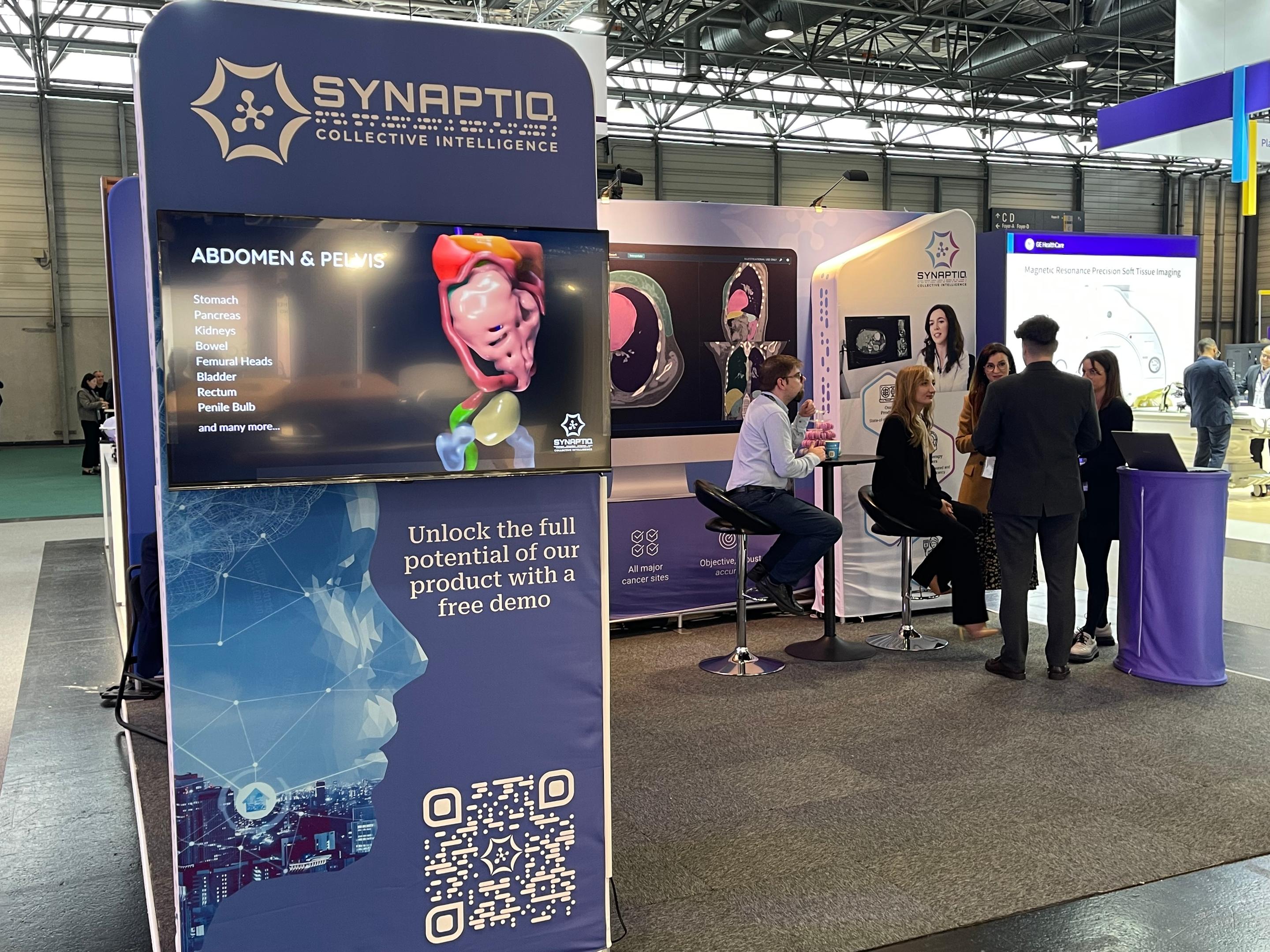 Synaptiq's stand. A stand with medical information and people standing at the stand
