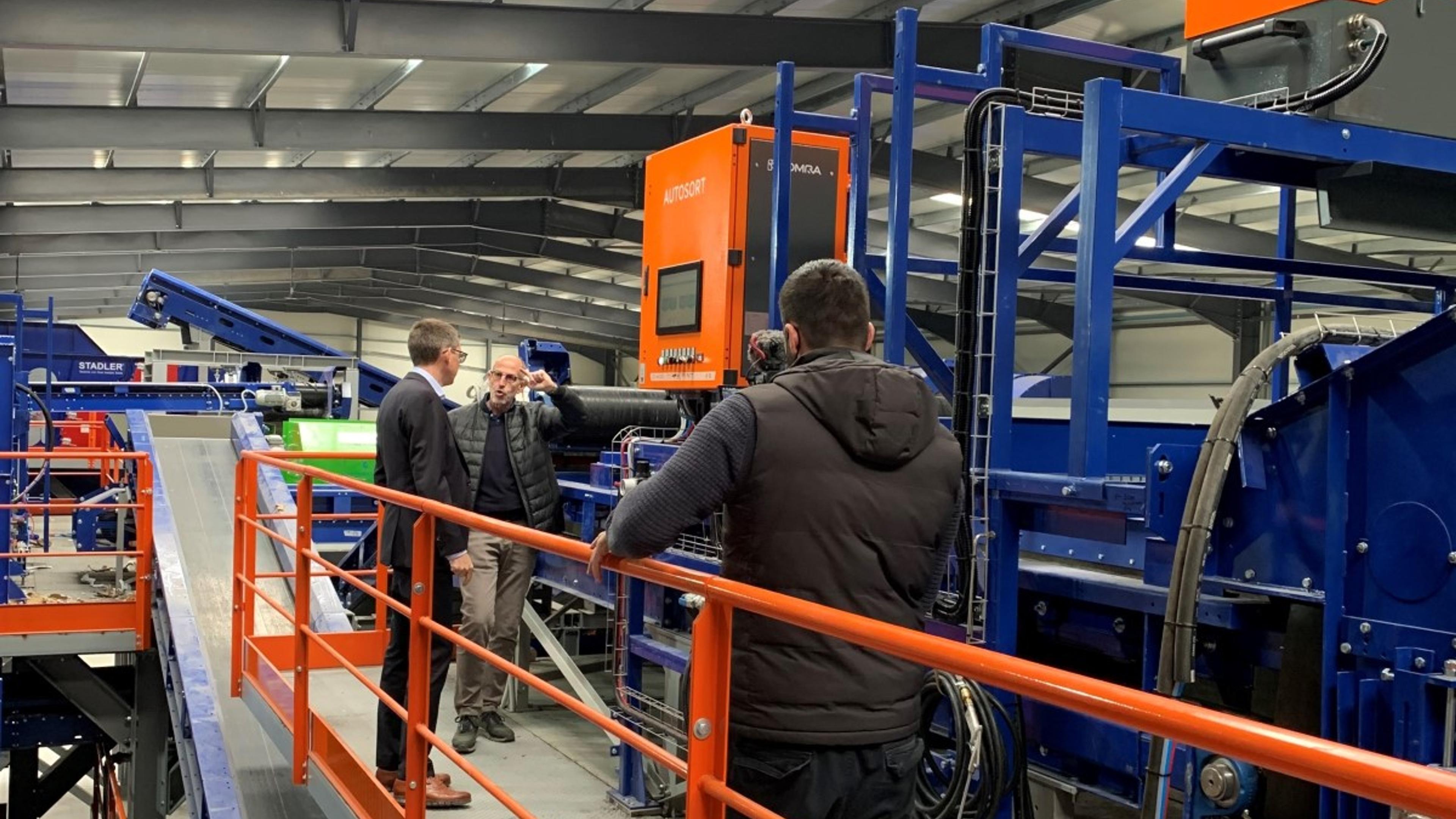 Tre menn inne i et industrianlegg