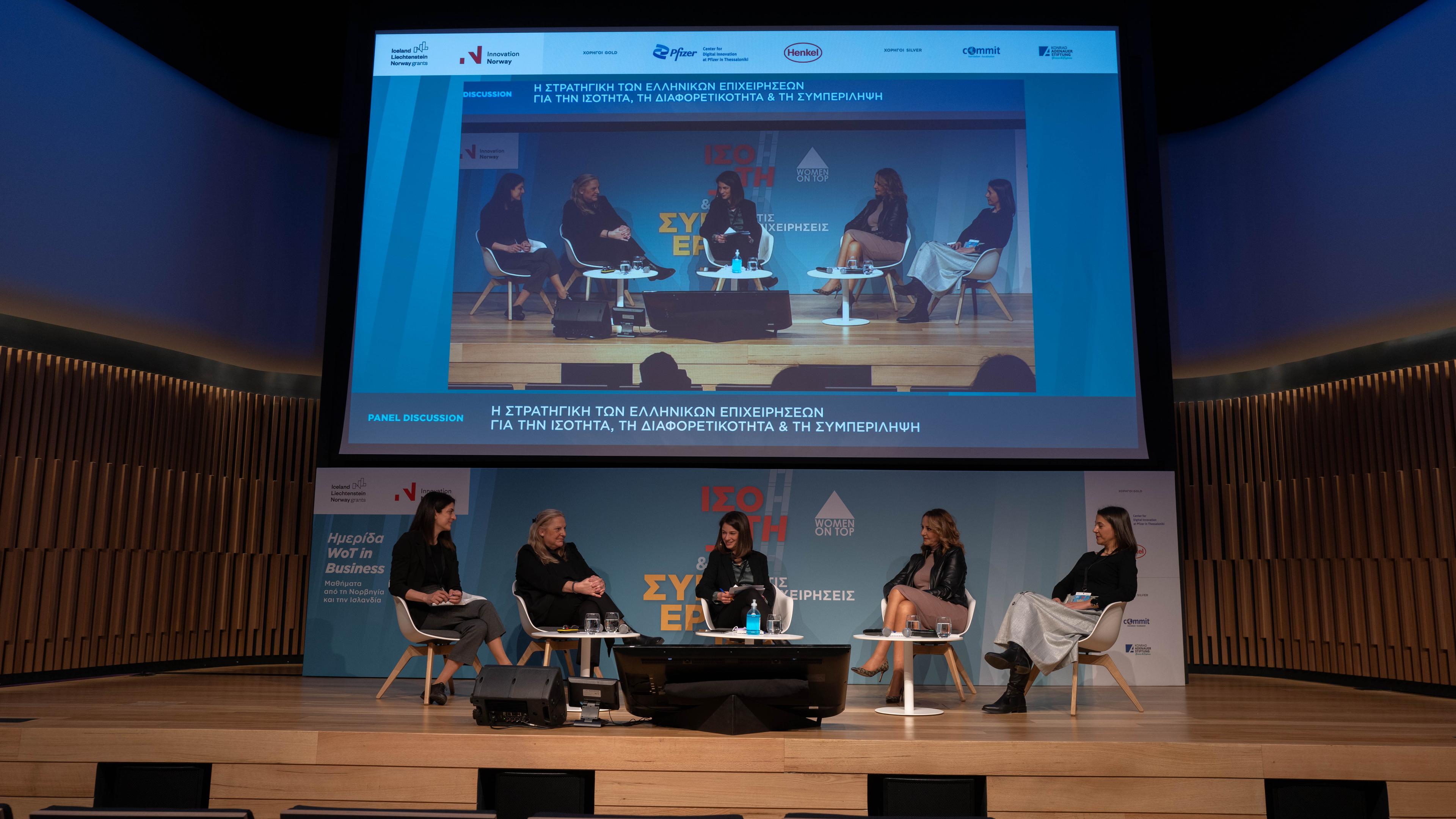 Women in a debate on a stage