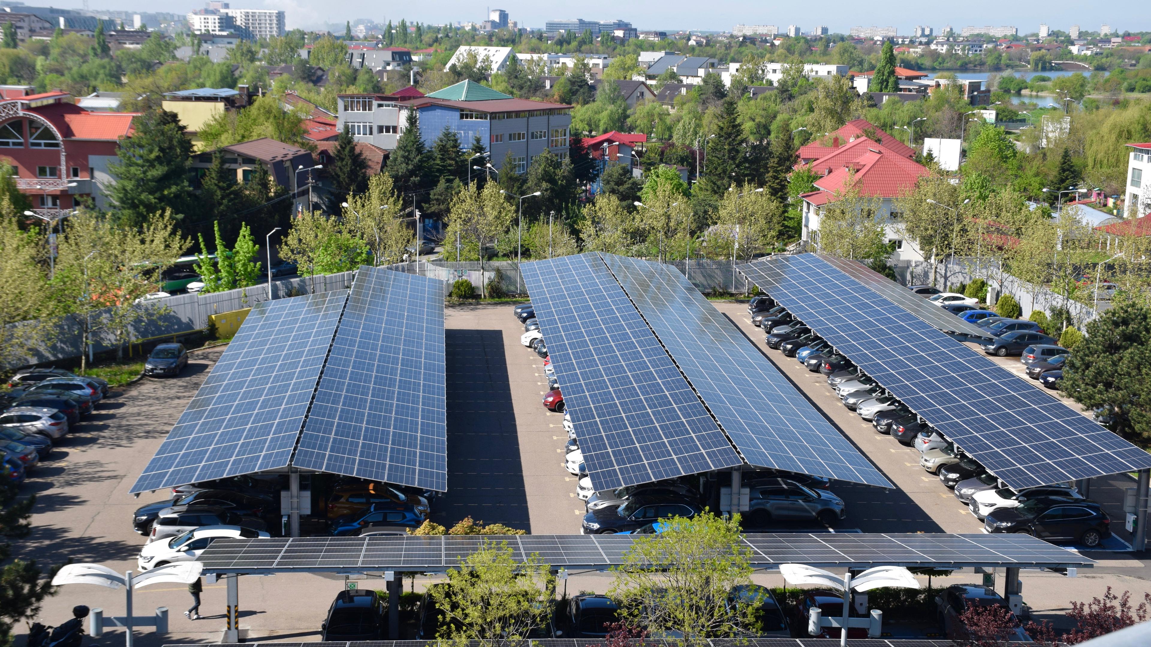 Three rows of solar panels providing shade for cars