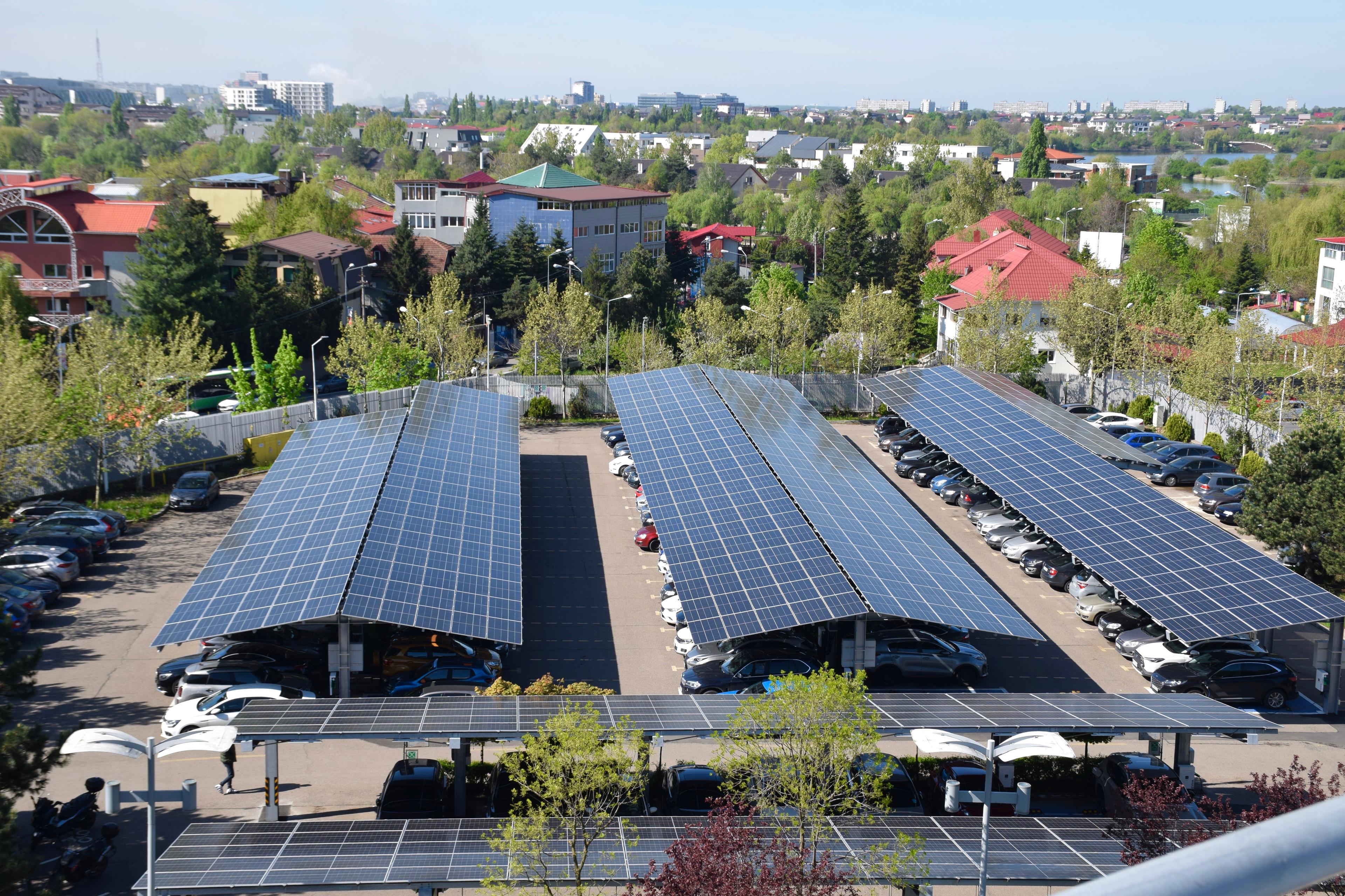 Three rows of solar panels providing shade for cars