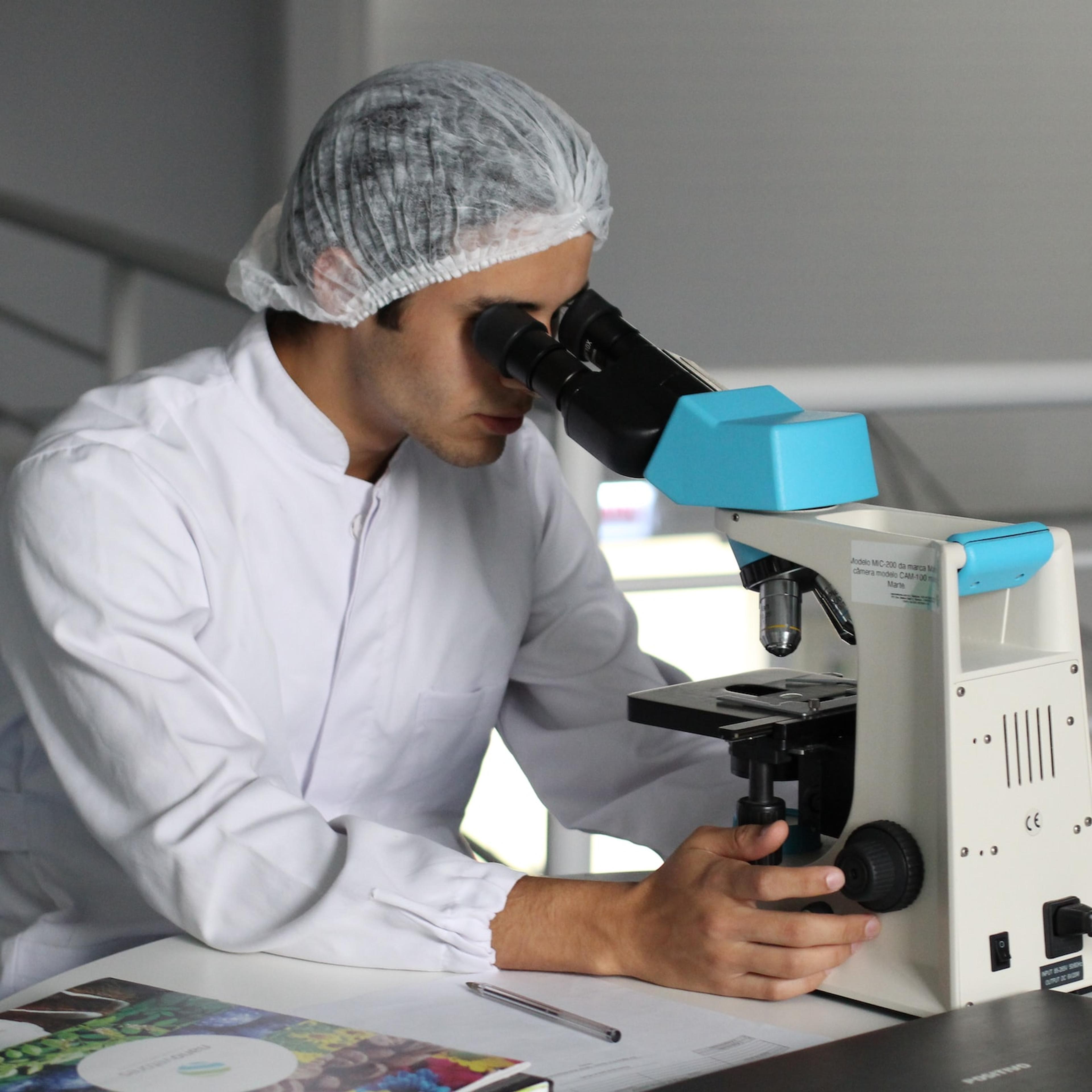 Researcher studying something in a microscope