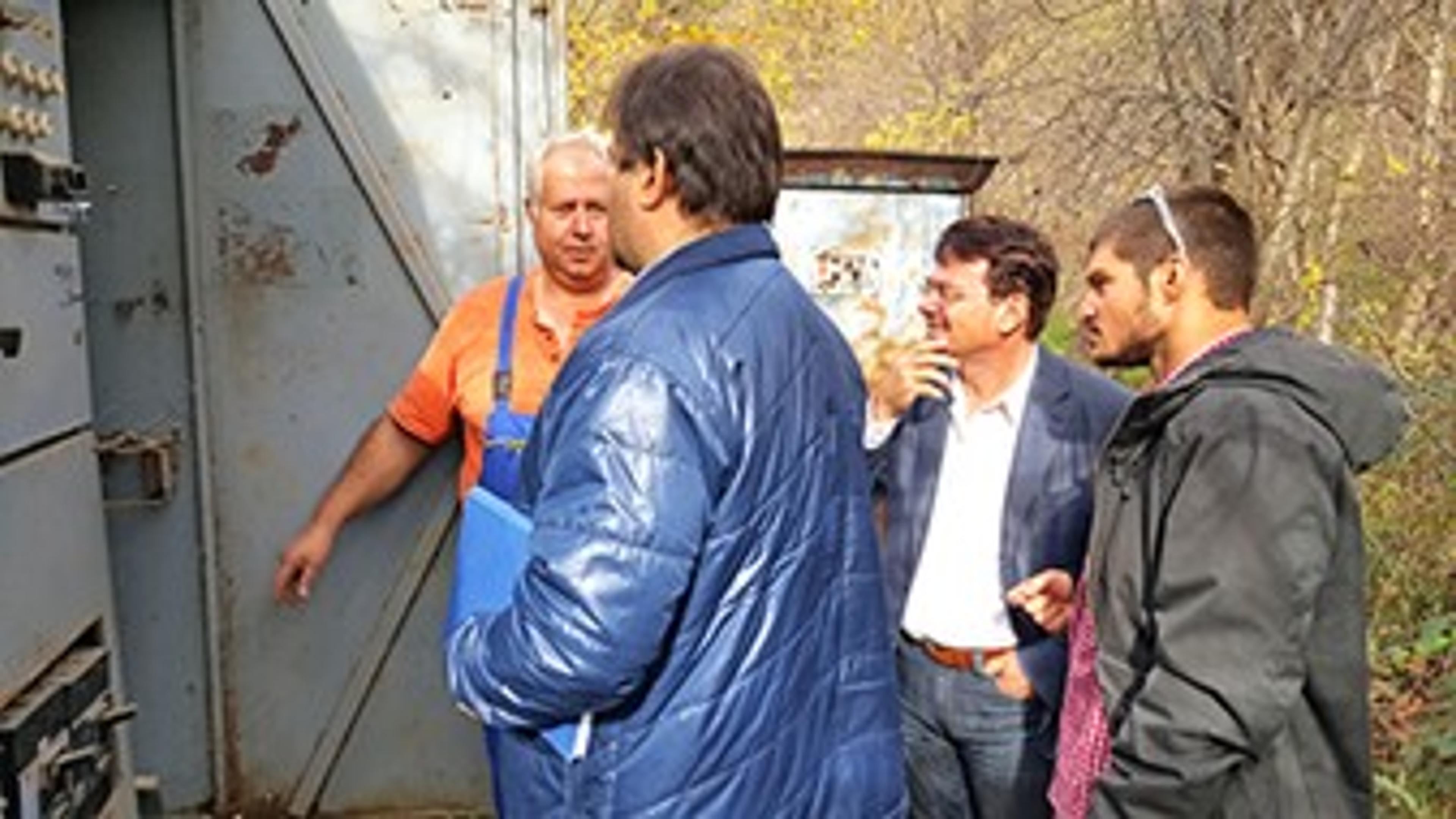 4 men looking at energy saving container