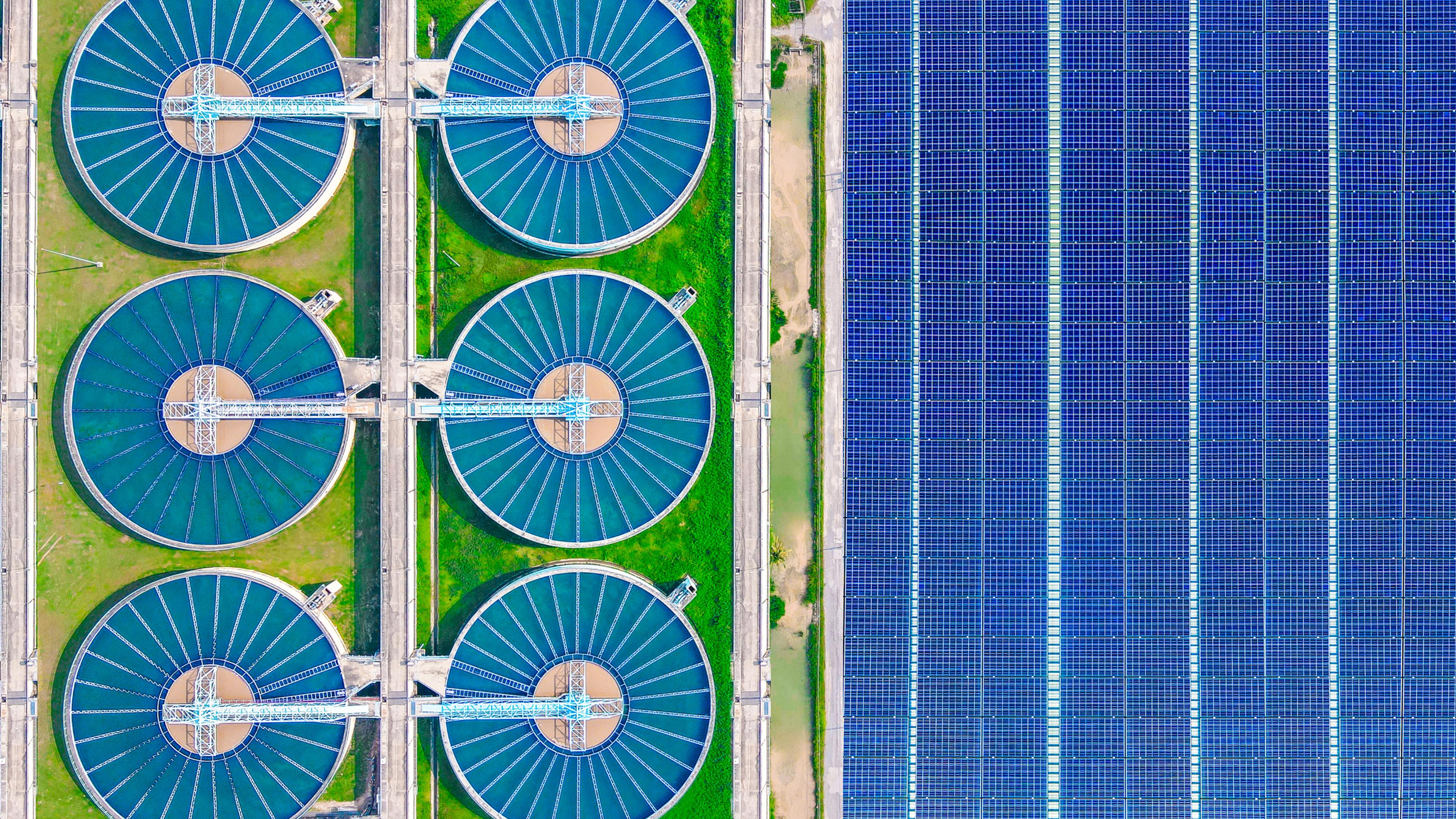 Aerial view of solar cells near a wastewater treatment pond
