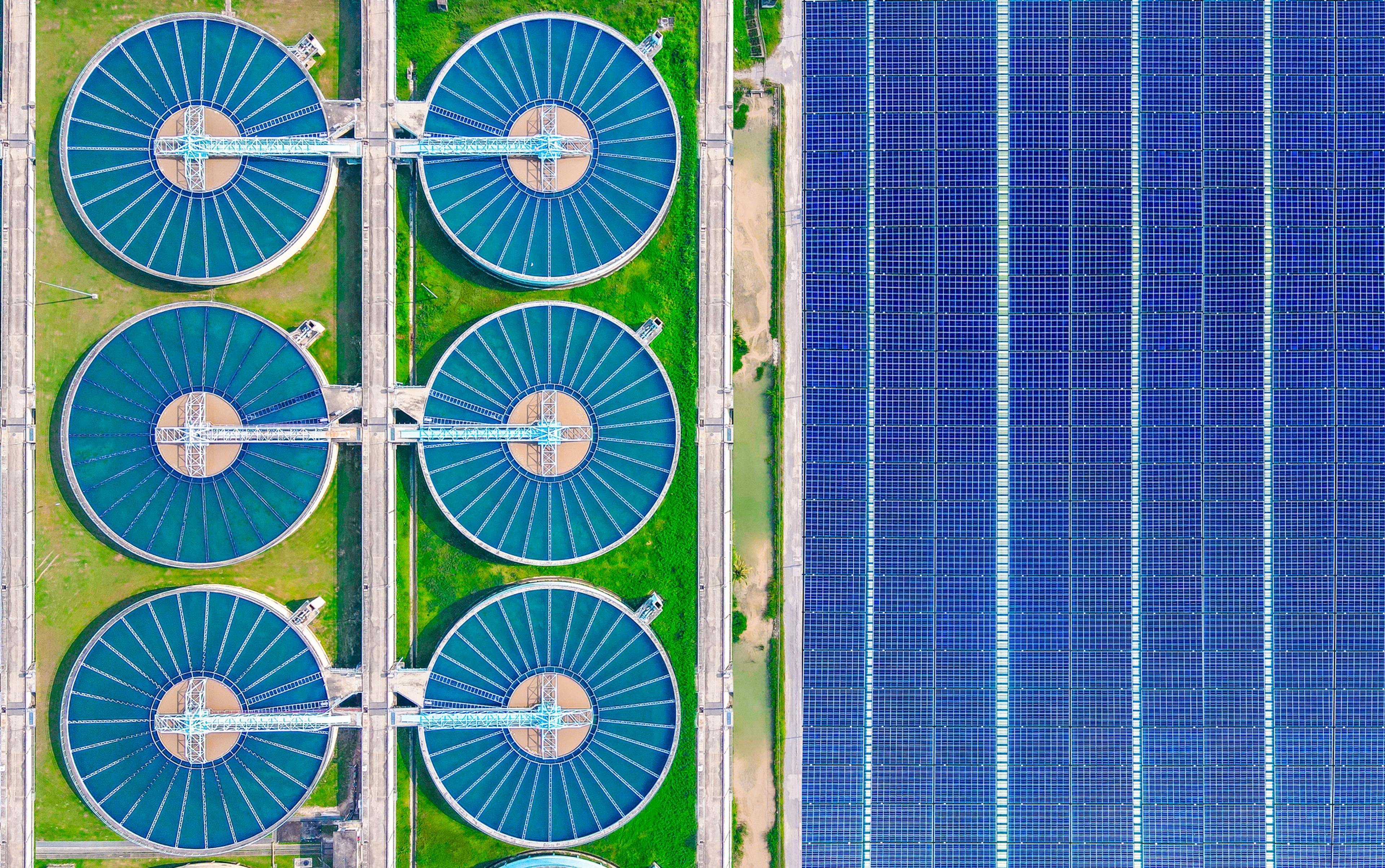 Aerial view of solar cells near a wastewater treatment pond