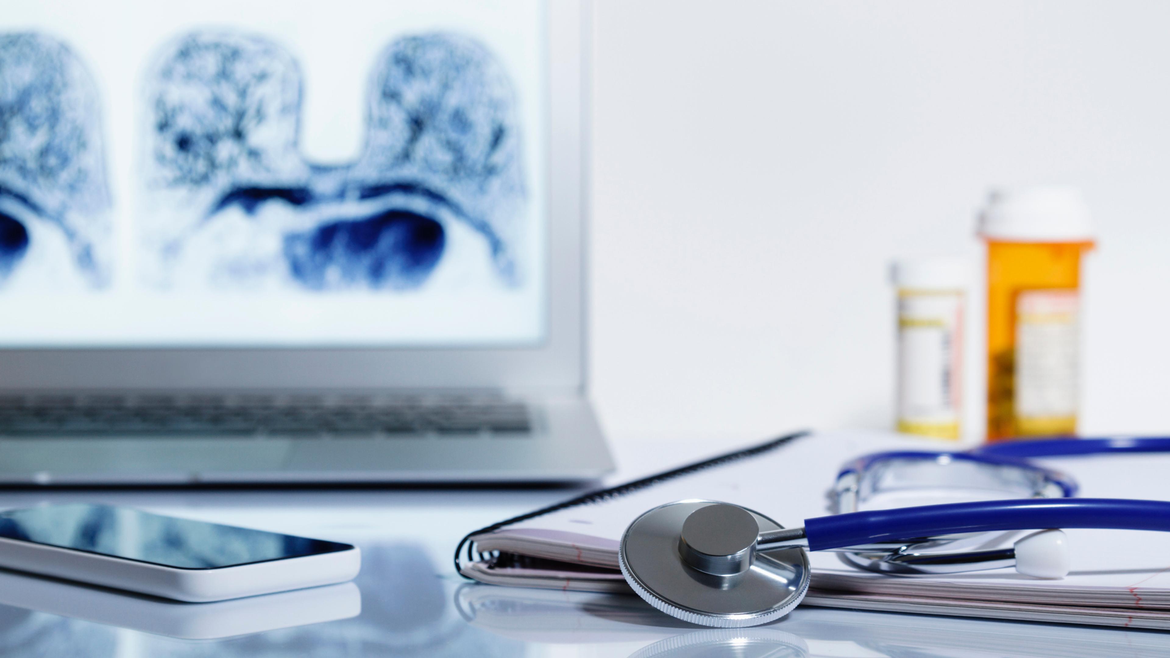 Acoustic stethoscope and laptop displaying MRI image