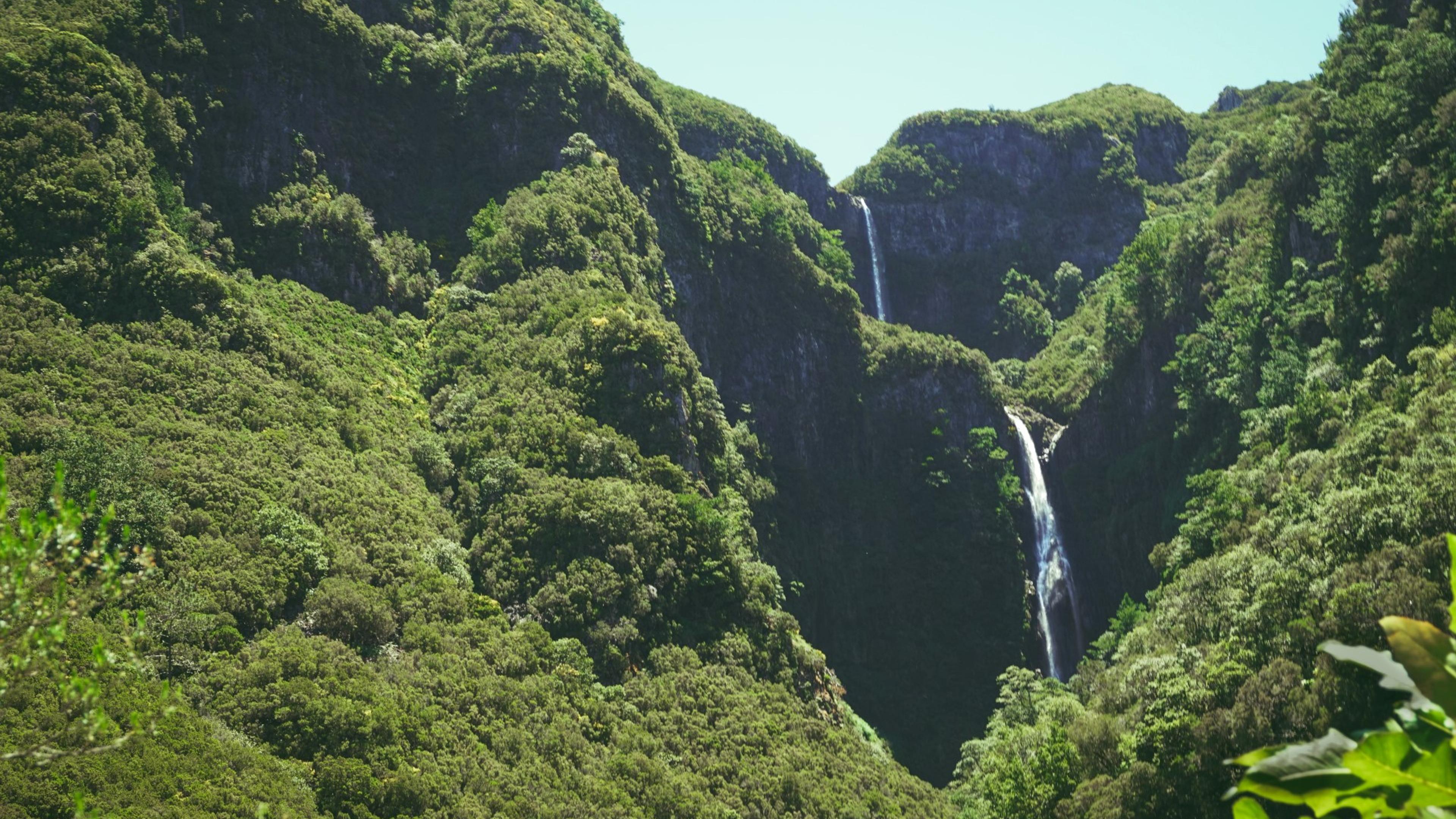 Fossefall nedover en grønn fjellside