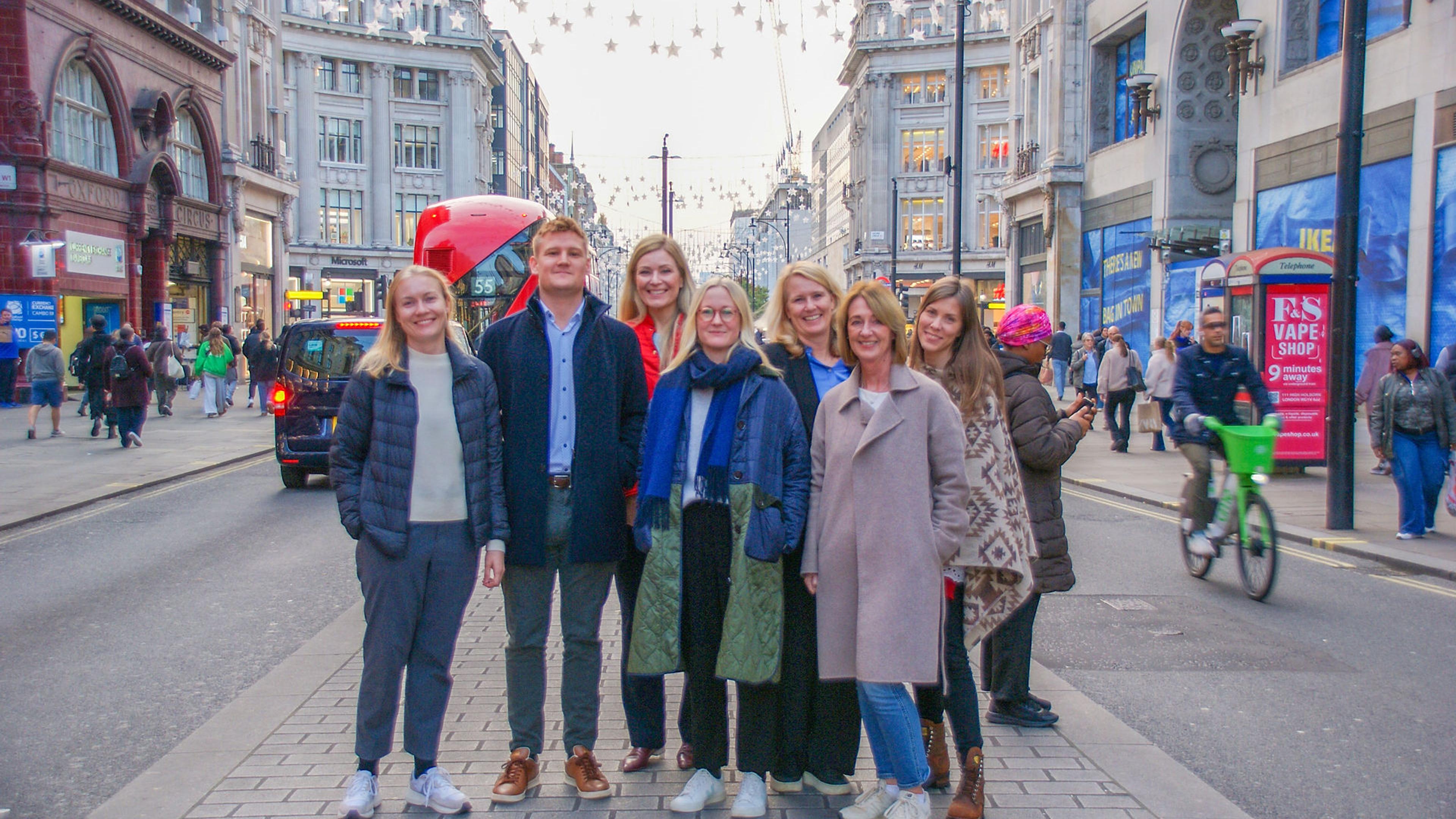 En gruppe mennesker som står midt i Oxford Street