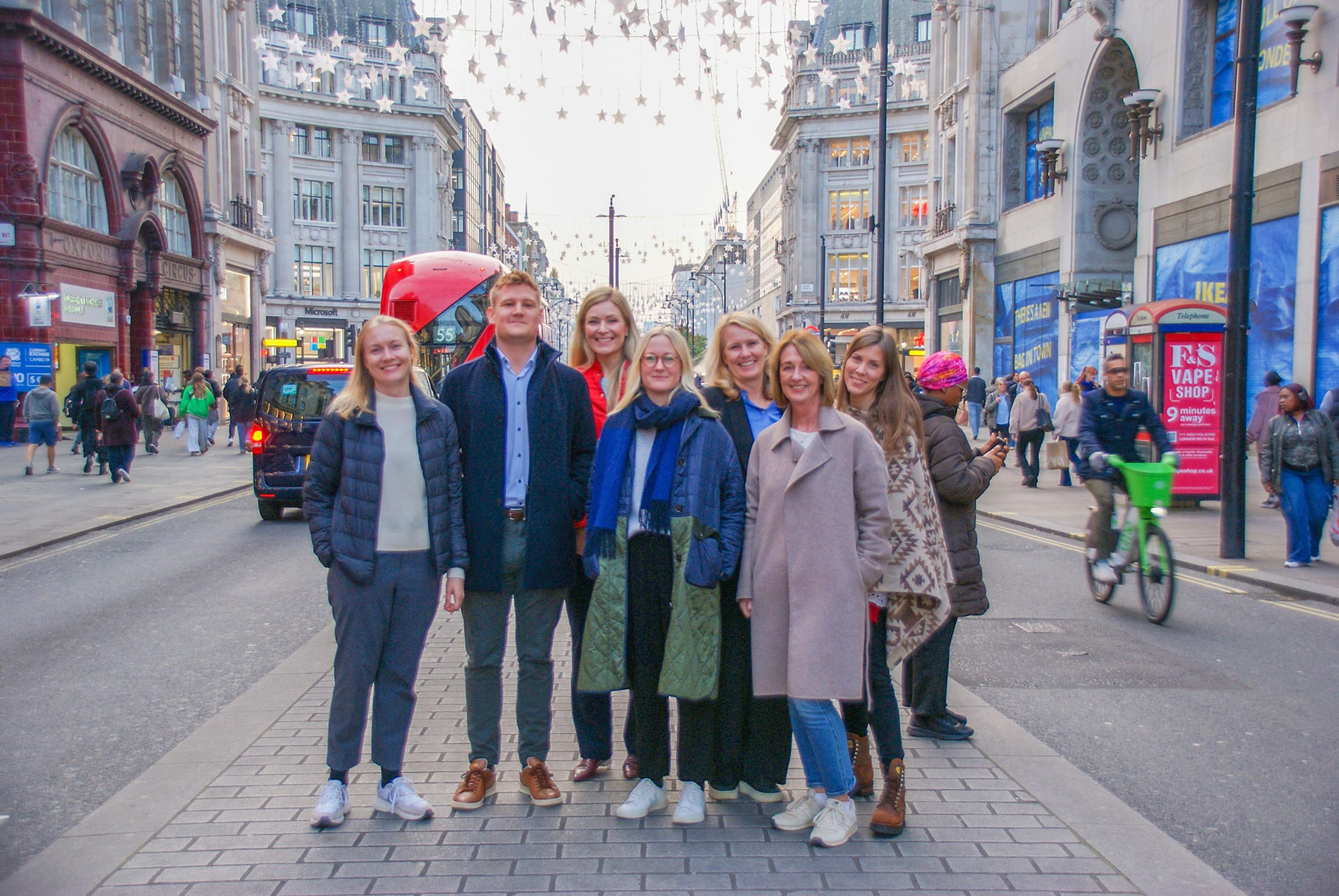 En gruppe mennesker som står midt i Oxford Street