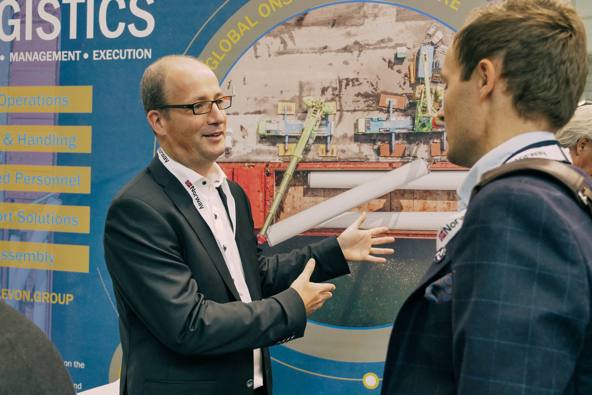 To business men talking togehter at a wind energy event