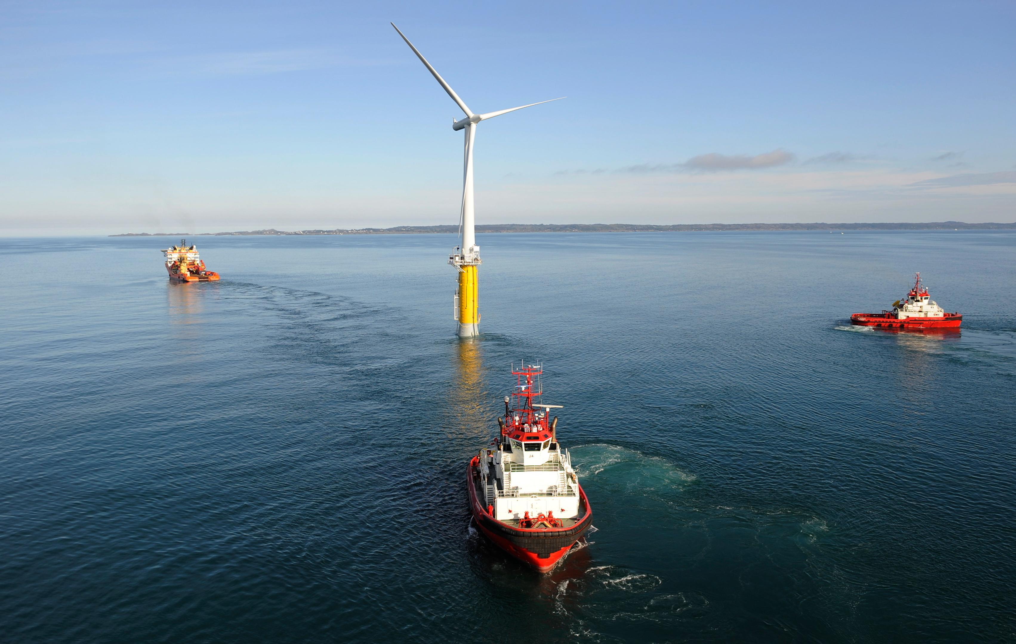 Three offshore vessels manouvering floating offshore wind turbine