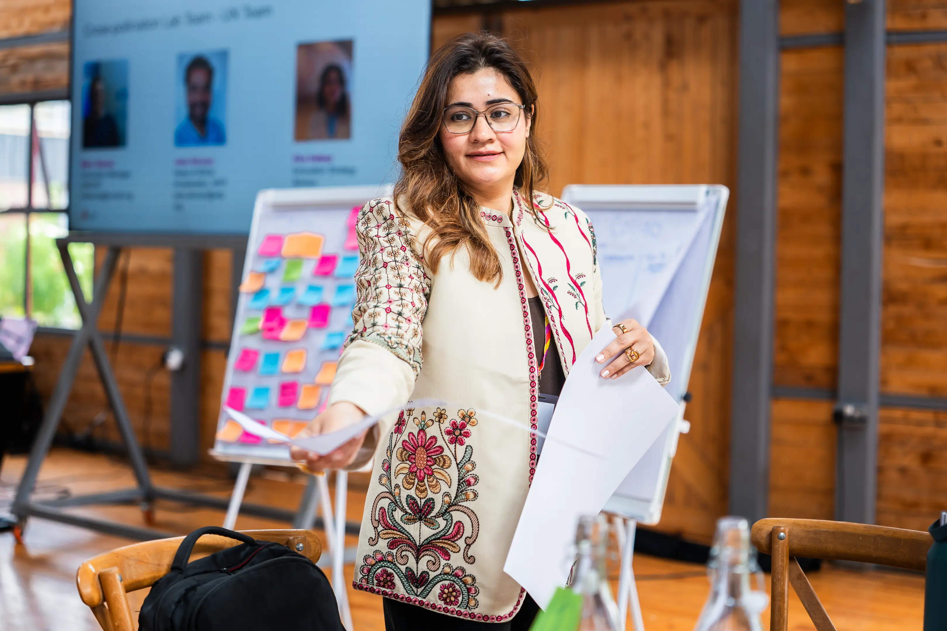 Woman at a conference, handing out a sheet of paper