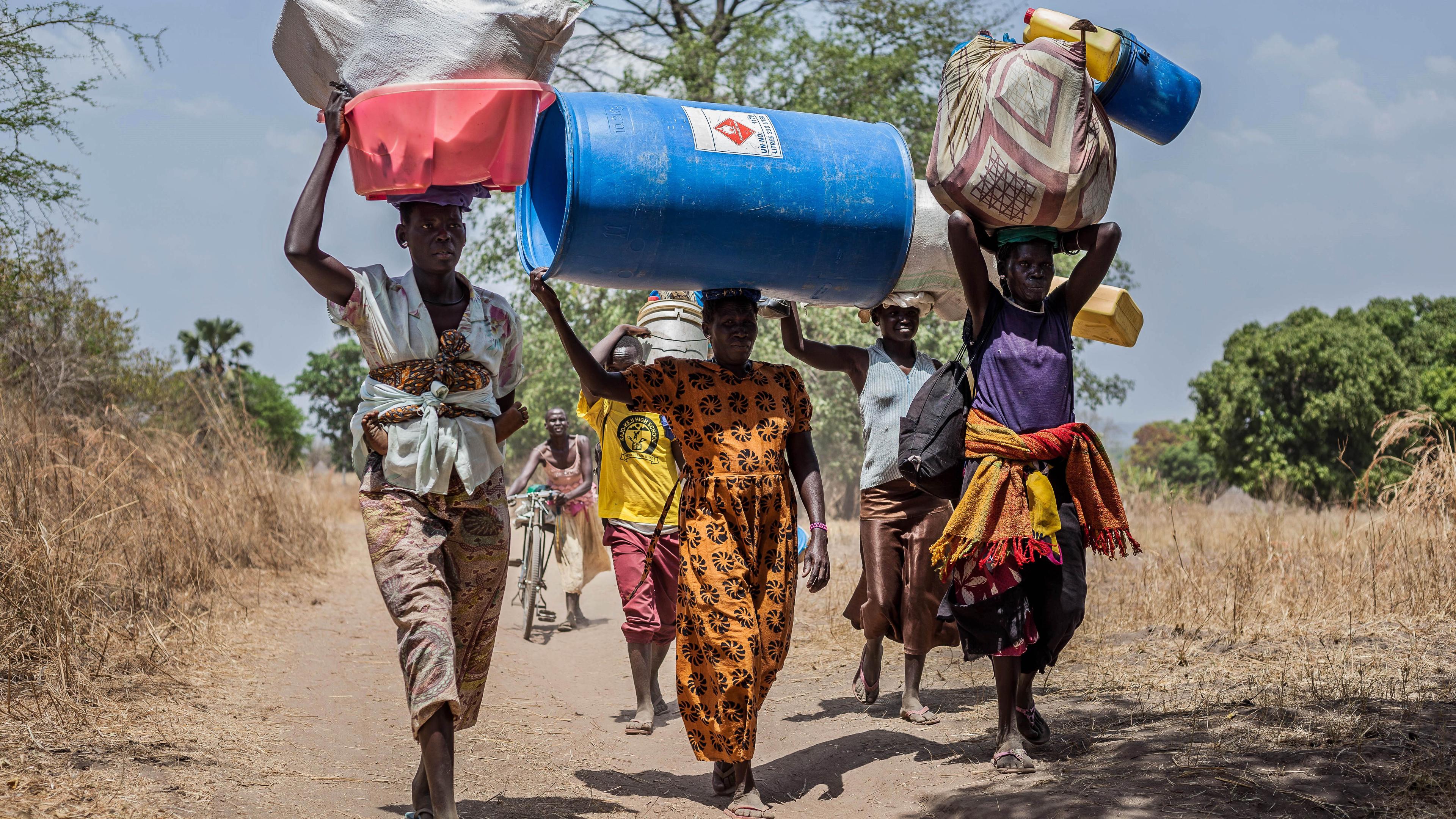 African people carrying water containers on their heads