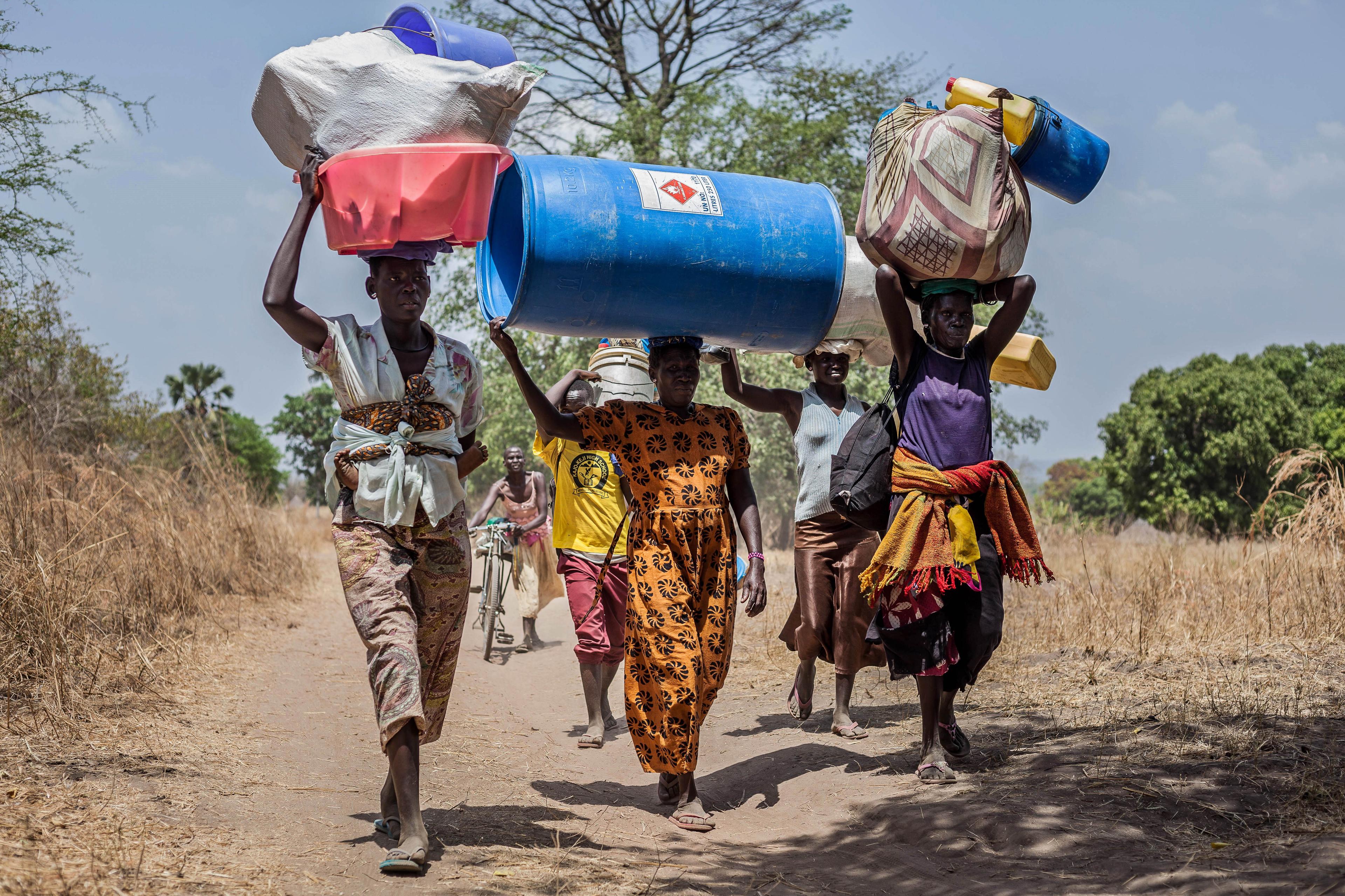 African people carrying water containers on their heads