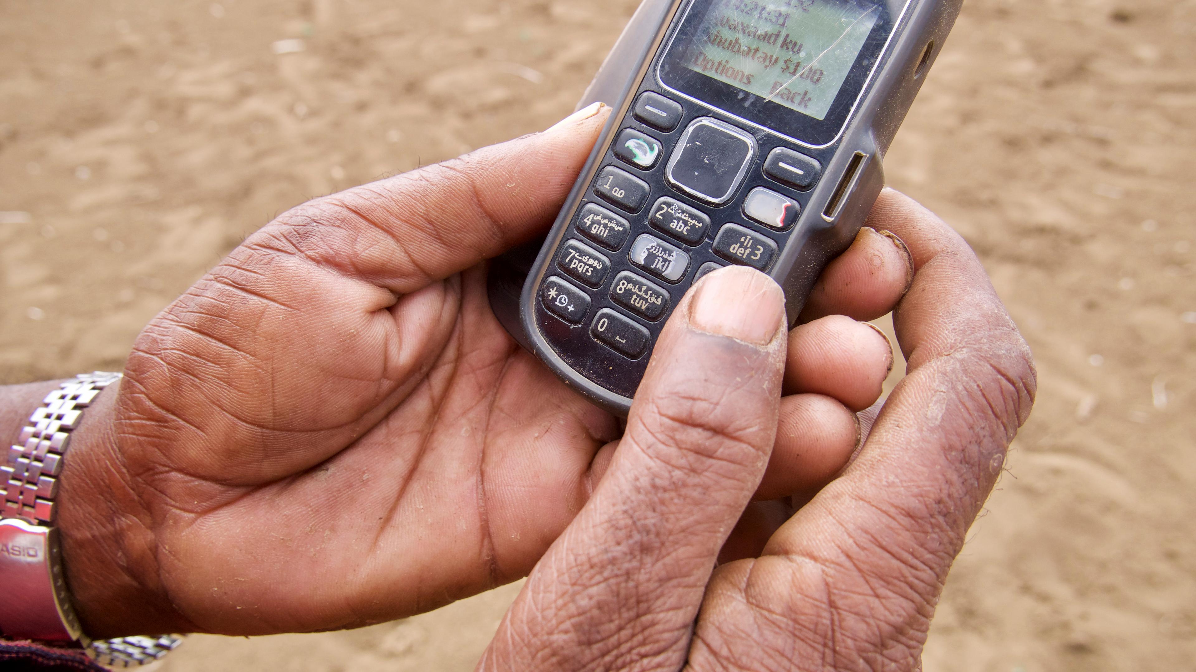 Hands holding an old mobile phone