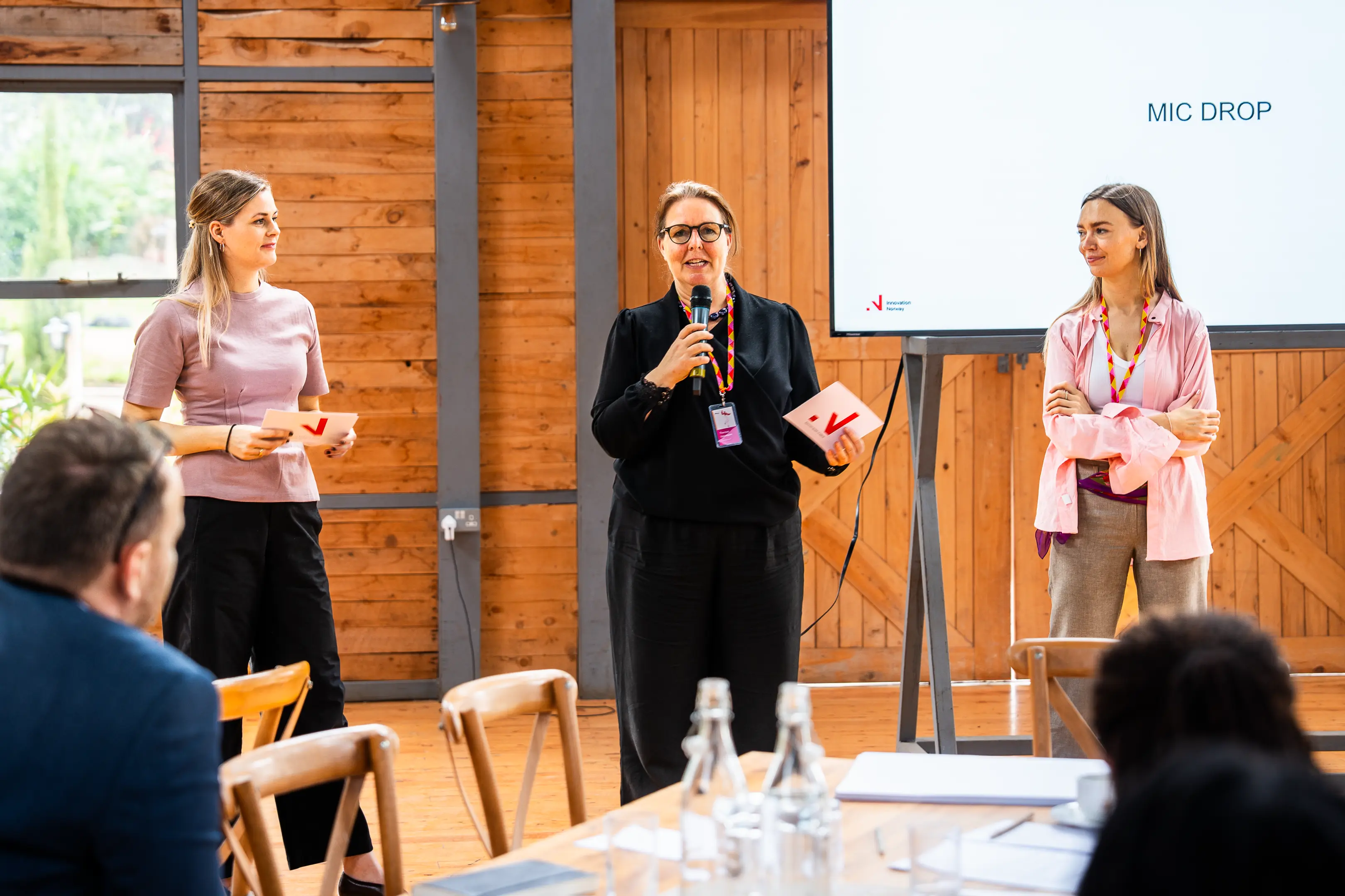 Three women speaking at a conference.