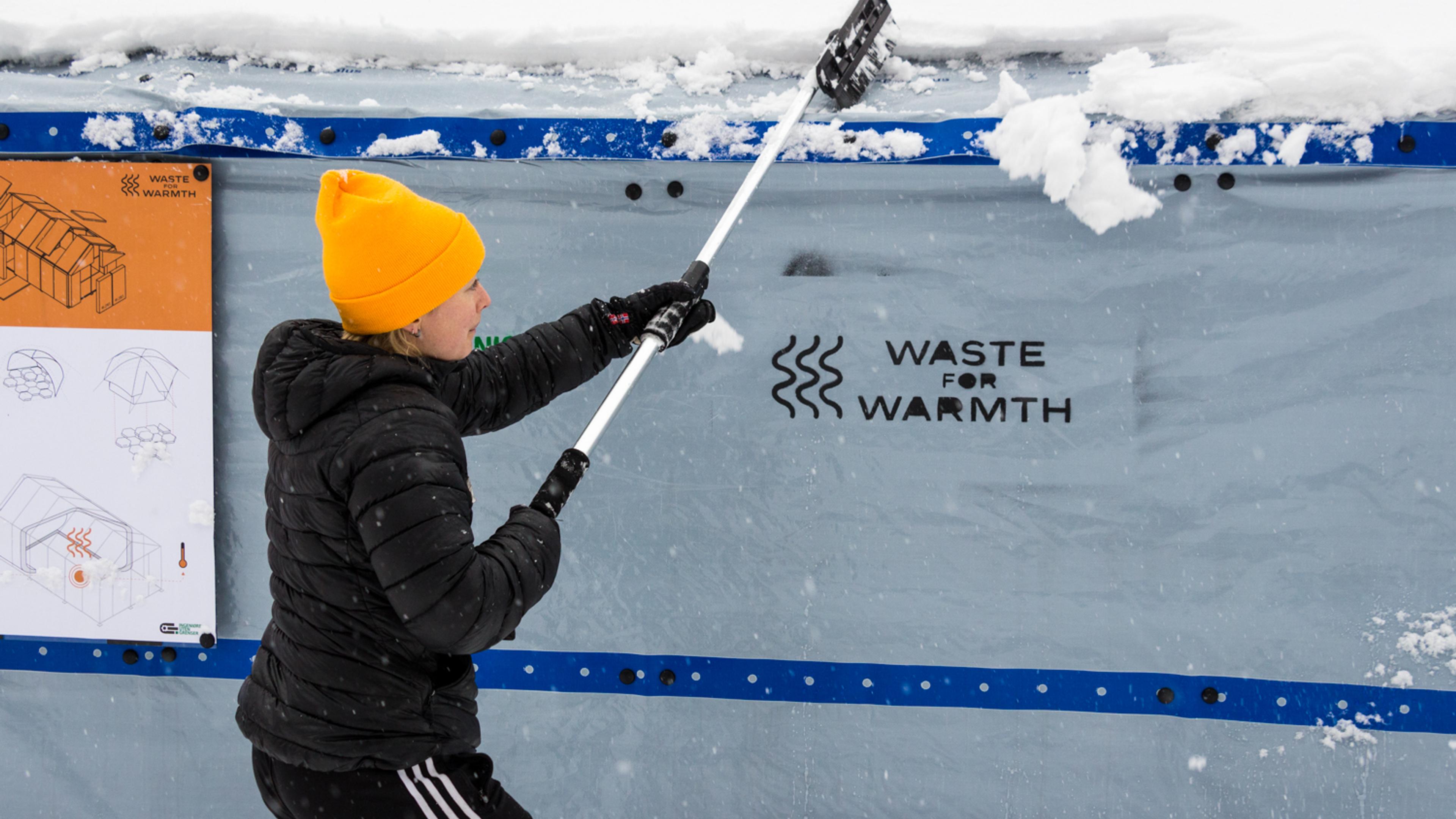 Girl removing snow from a camp tent