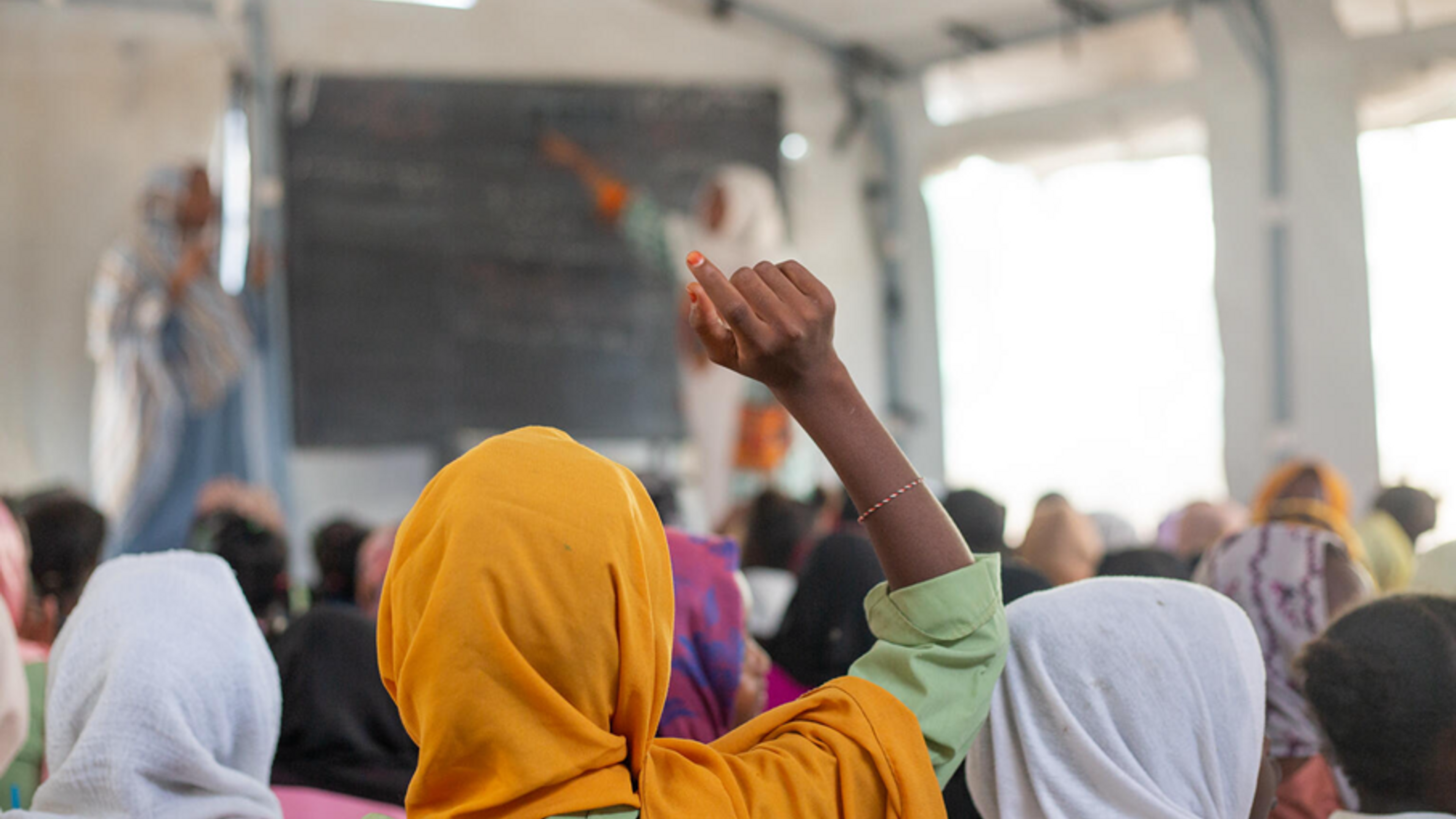 Girl raising her hand in a classroom