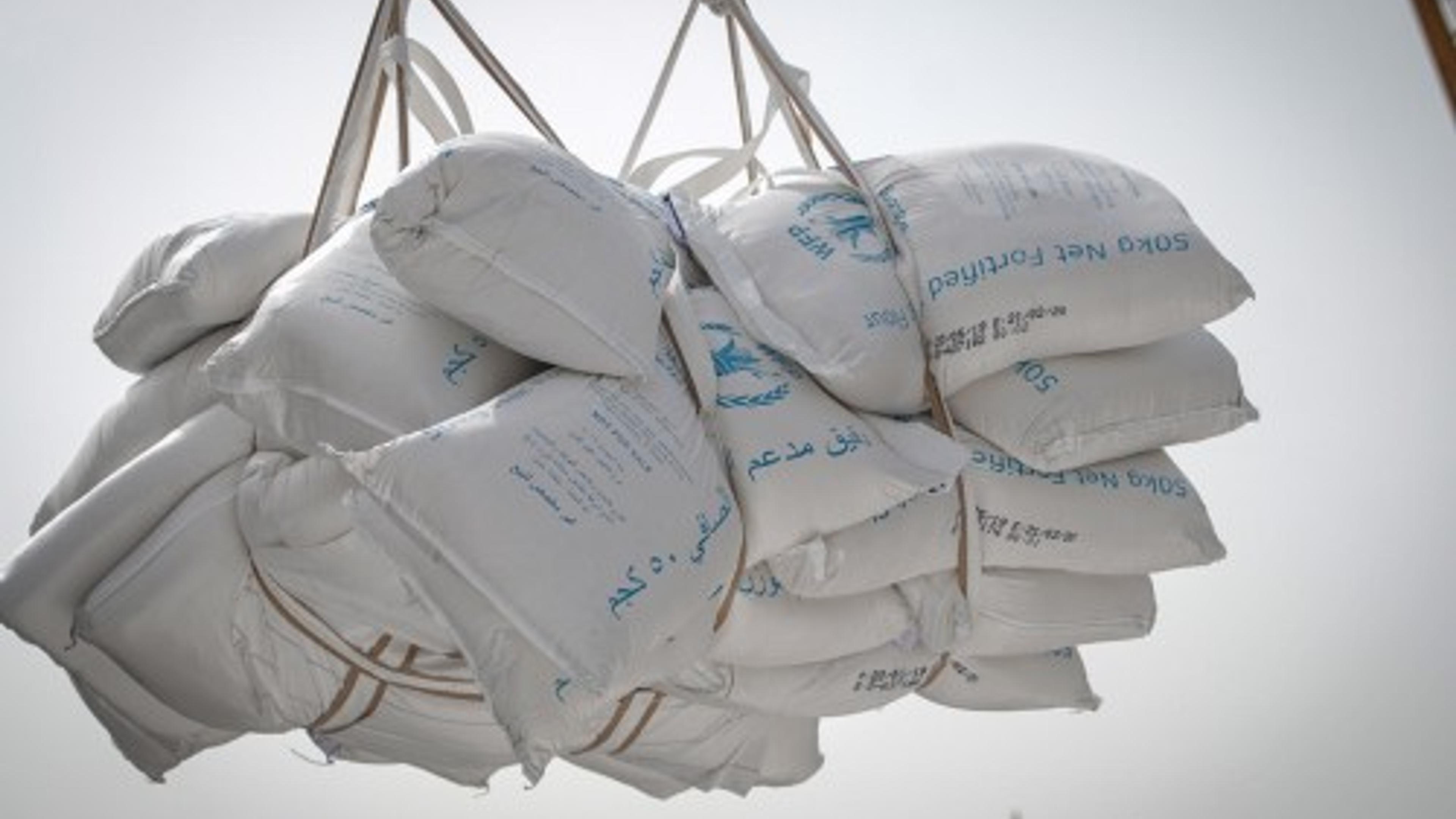 A bunch of big plastic bags with rice being transported
