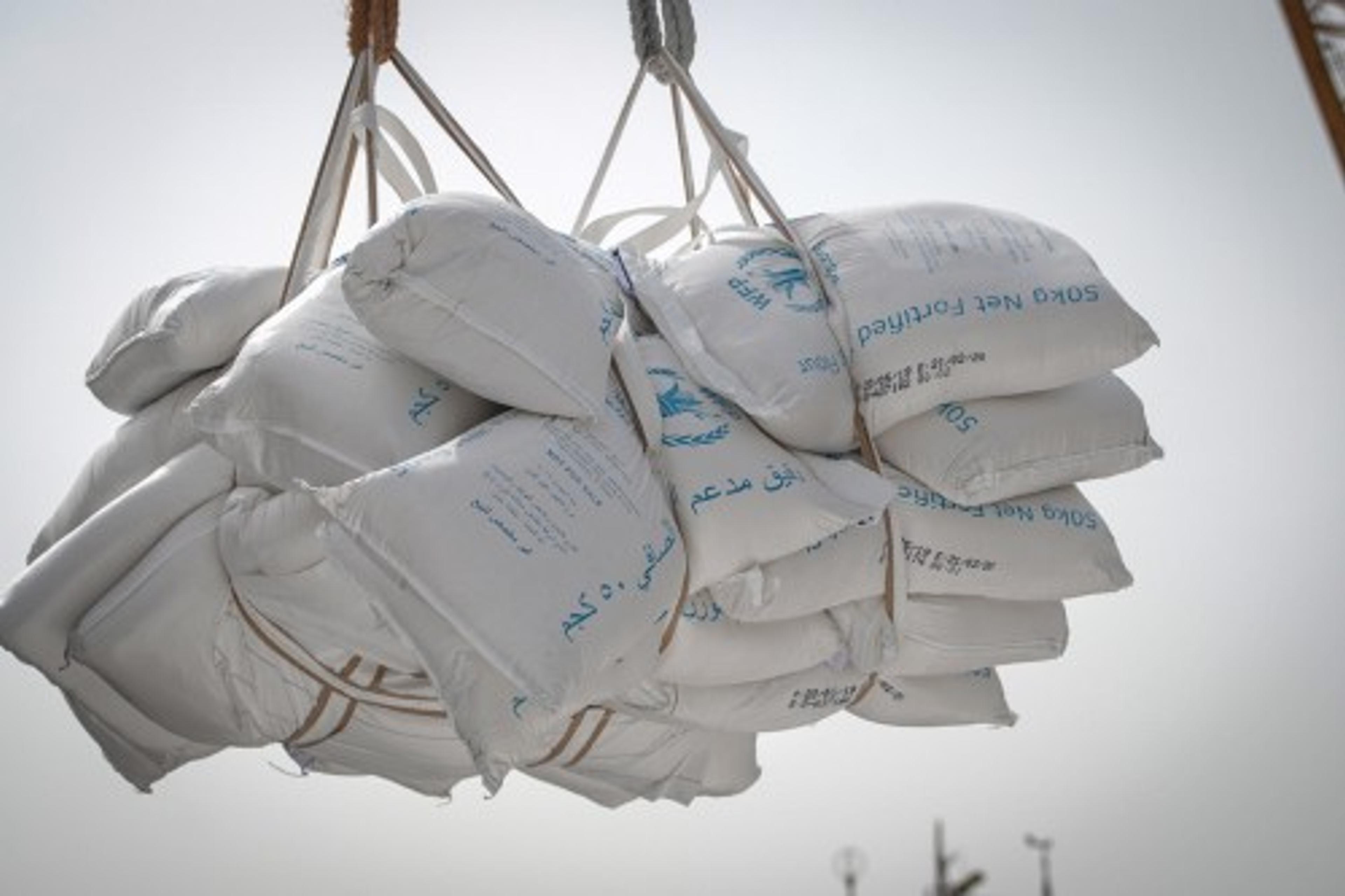 A bunch of big plastic bags with rice being transported