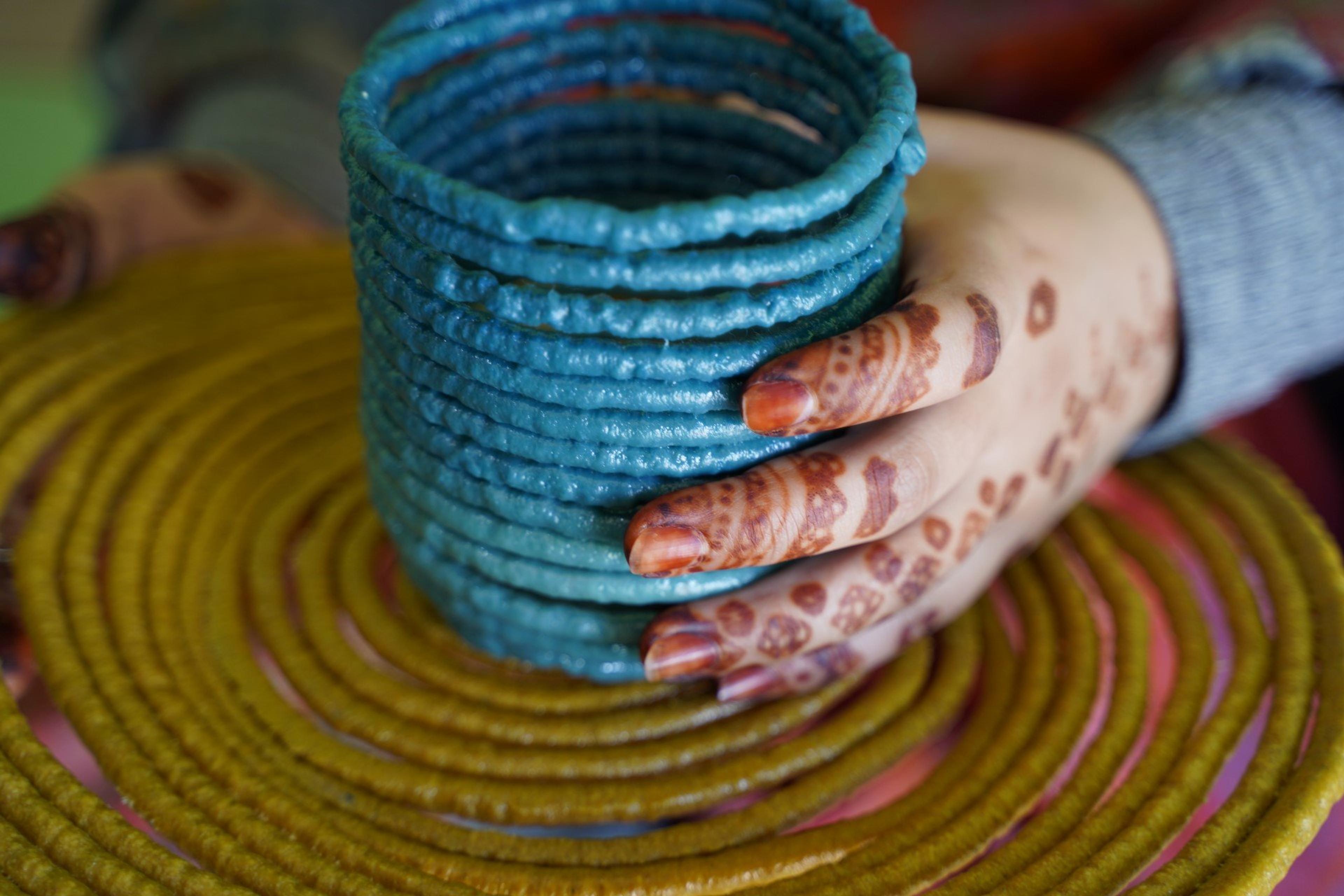 Kvinne med hennamalte fingre som lager nytt produkt av resirkulert plast
