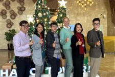 Seks ansatte ved Vietnam-kontoret står foran et juletre