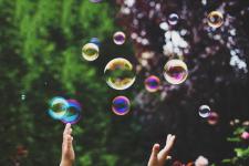 Hender som prøver å fange såpebobler